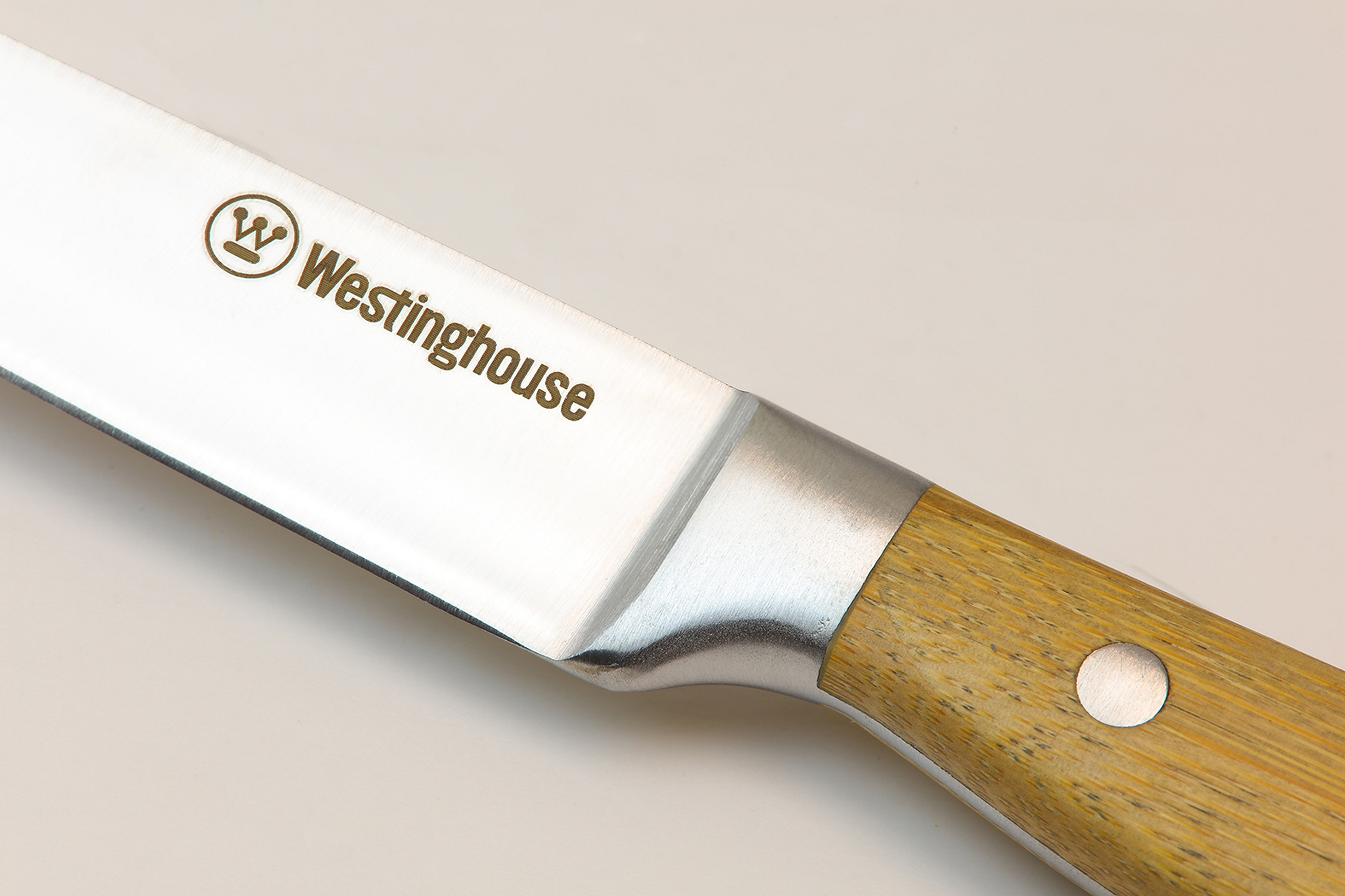 Nahaufnahme einer Messerklinge mit dem Westinghouse-Logo und Holzgriff.