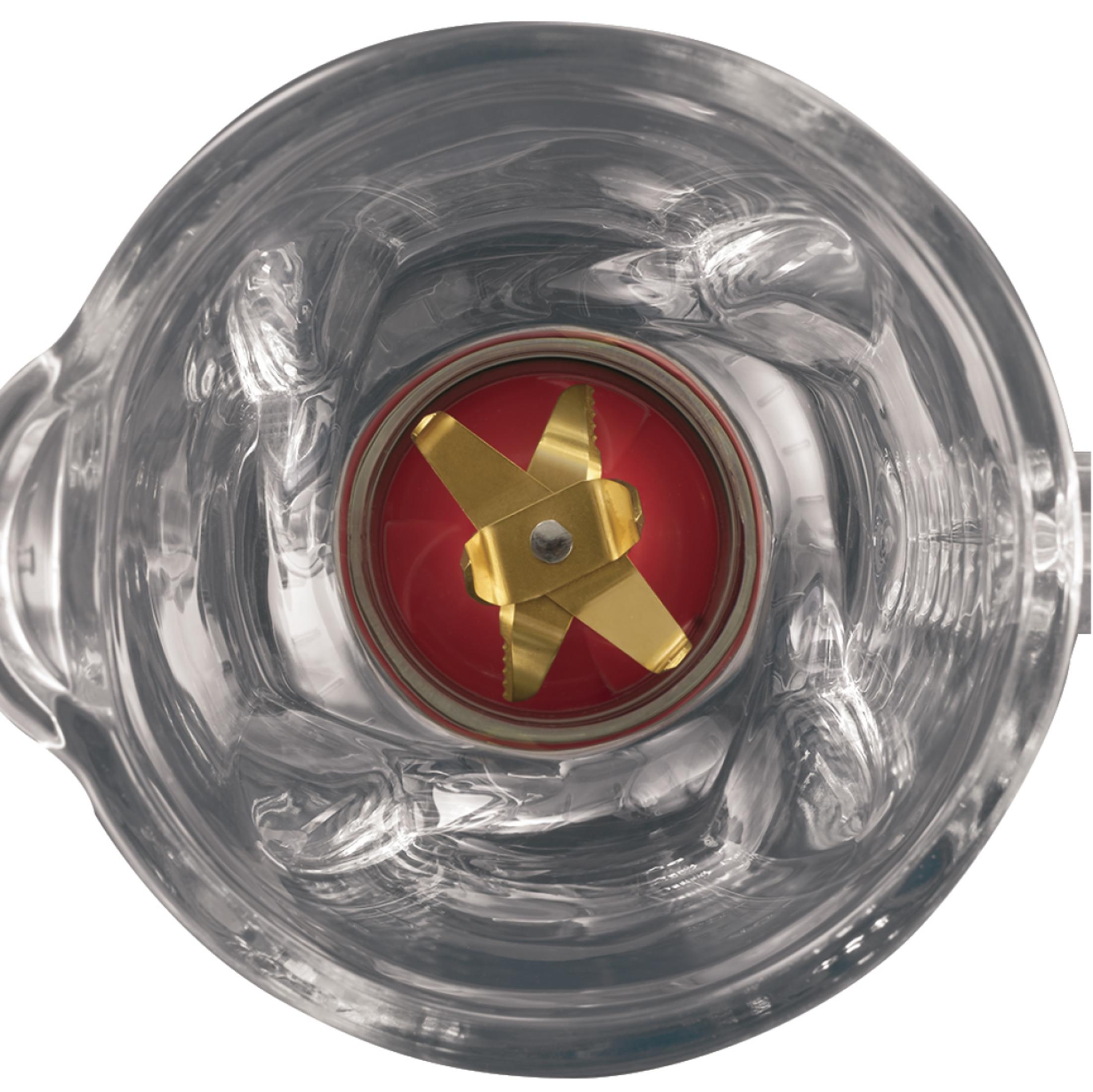 Der Glasbehälter eines Mixers wird von oben betrachtet. Eine goldene Klinge befindet sich innen auf roter Basis.