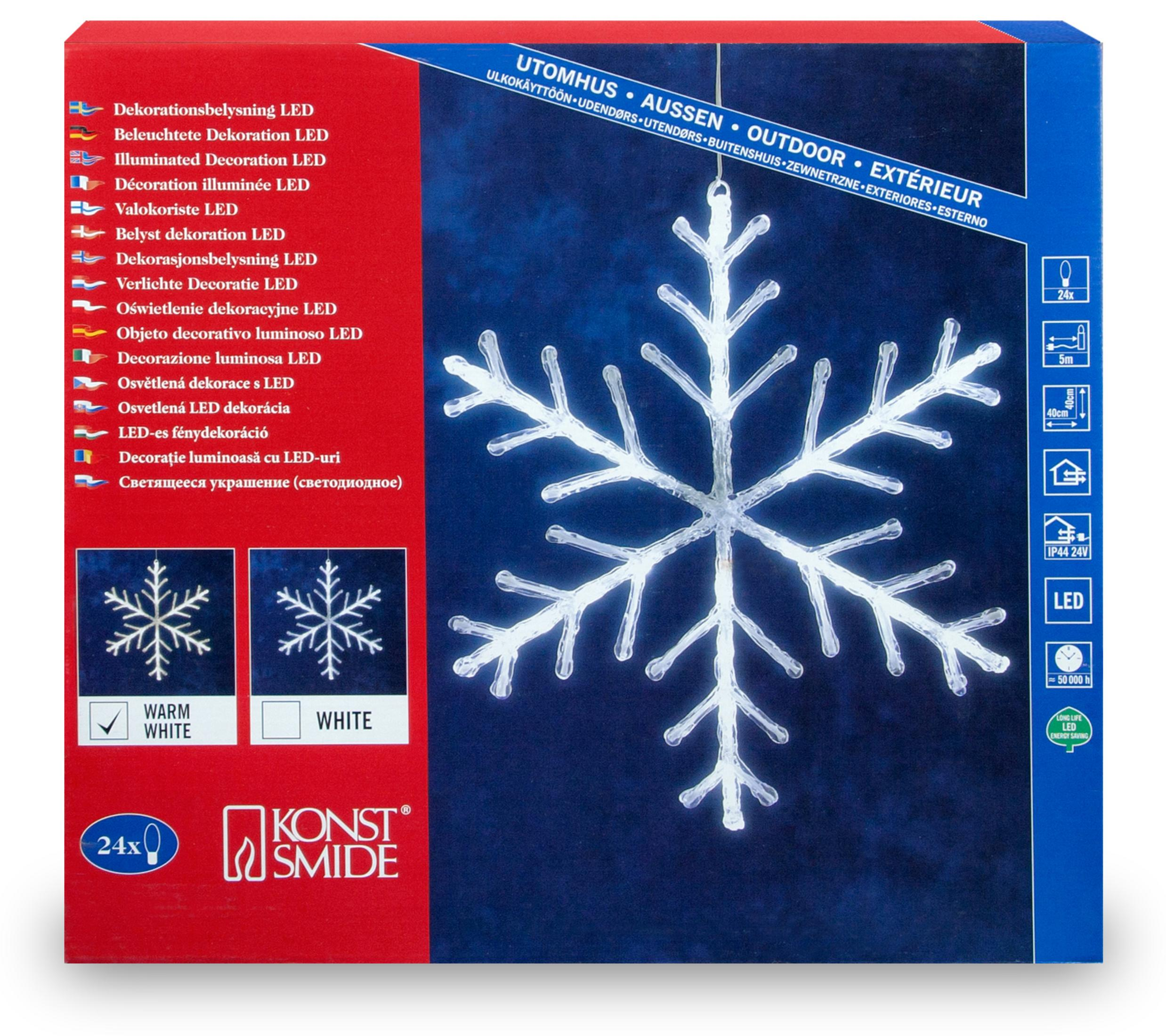 Eine weiße, beleuchtete Schneeflocken-Dekoration auf einer Box. Die Box hat Text und Bilder.