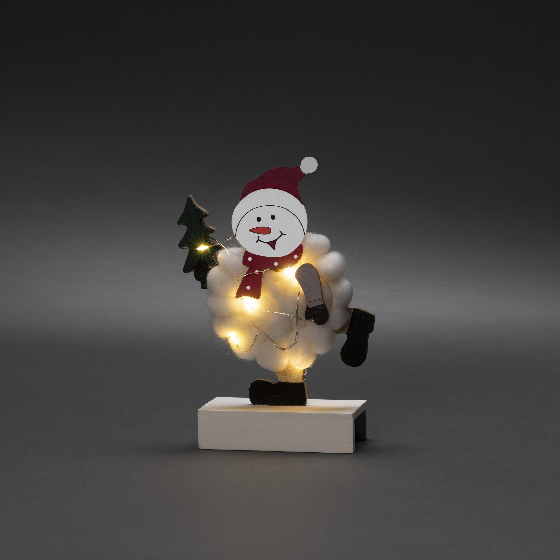 Schneemann-Ornament mit rotem Hut, Schal und kleinem Weihnachtsbaum.