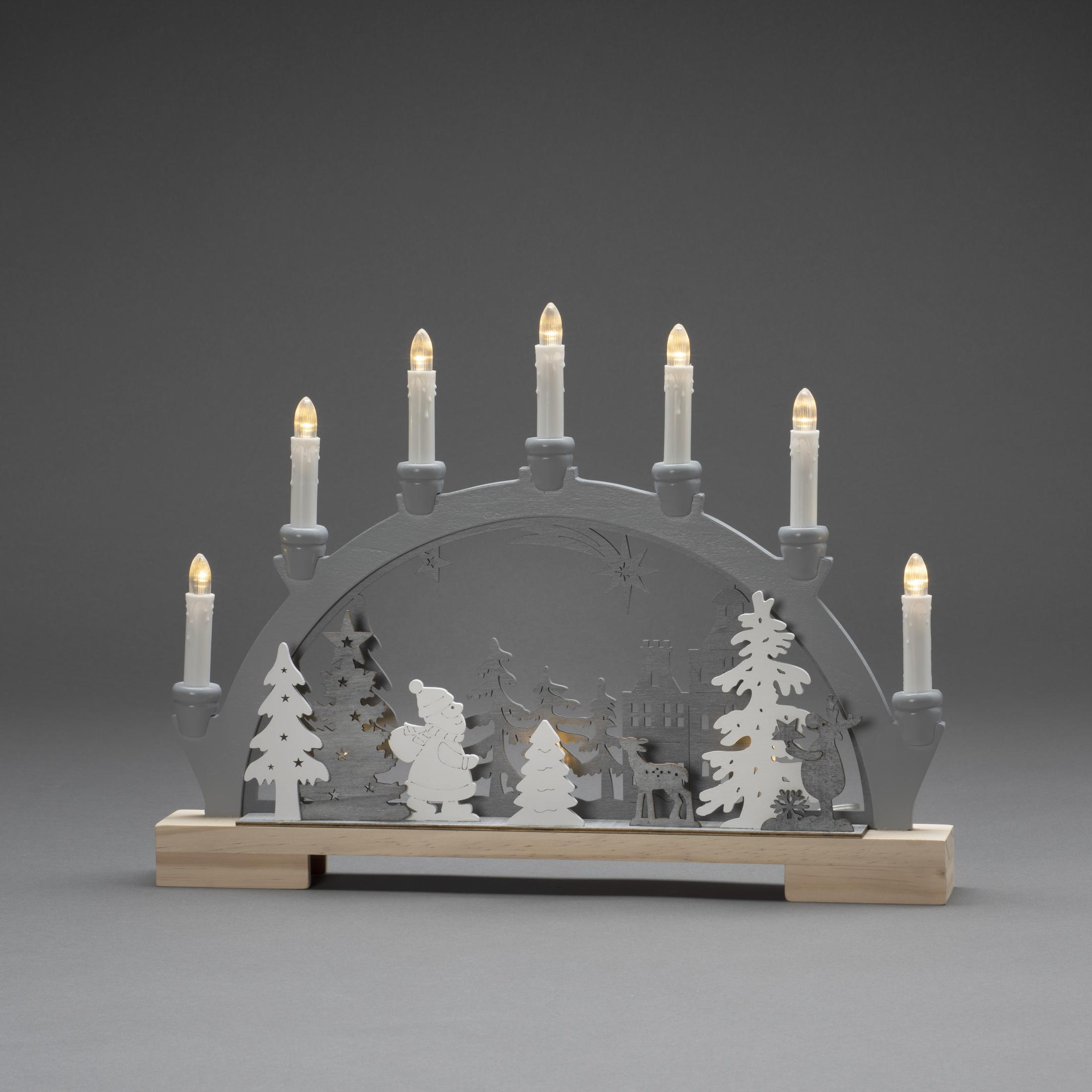 Graue Weihnachtsszene mit Weihnachtsmann, Bäumen und Häusern, beleuchtet von Kerzen.