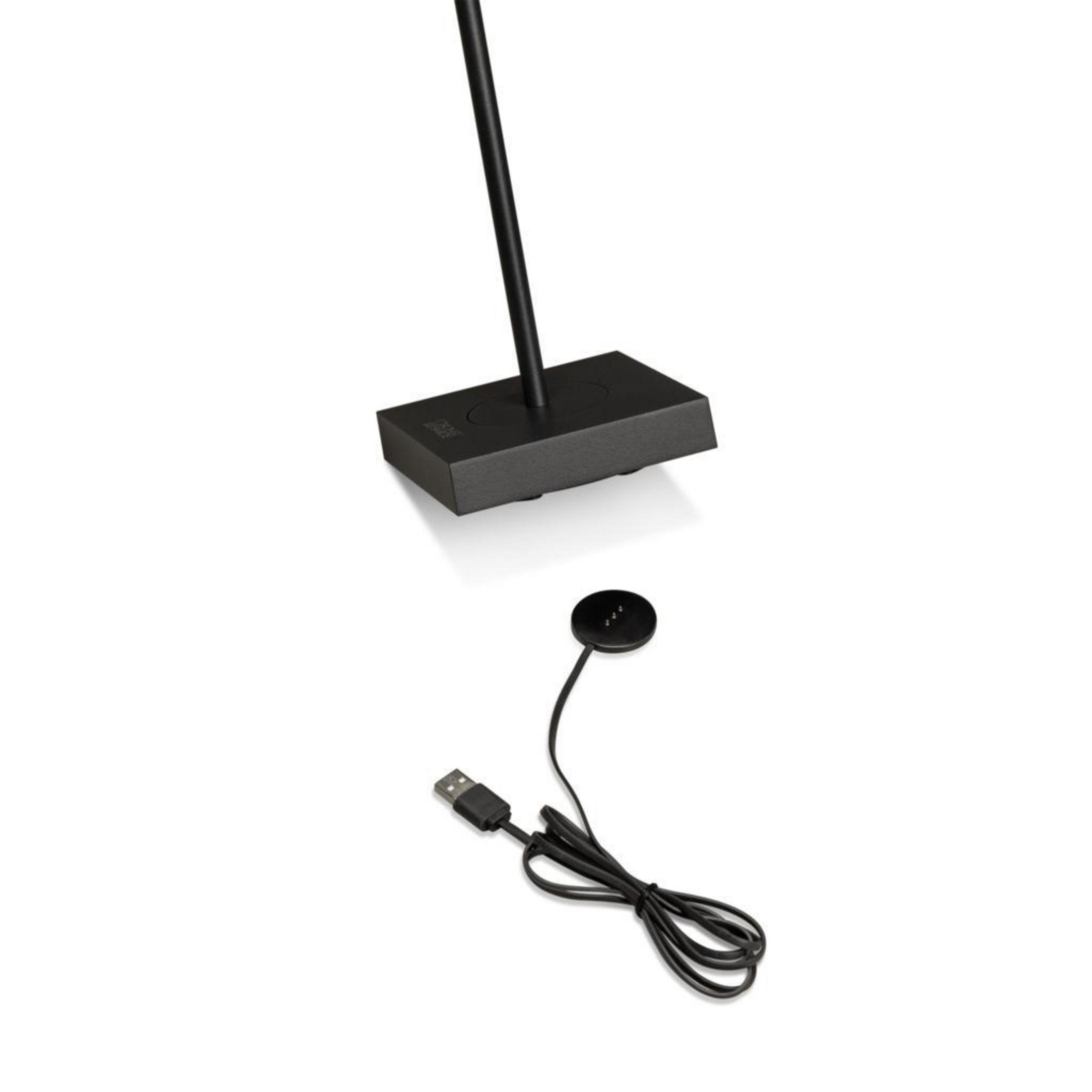 Stazione di ricarica nera e un caricatore per orologi con cavo USB. Sfondo bianco.