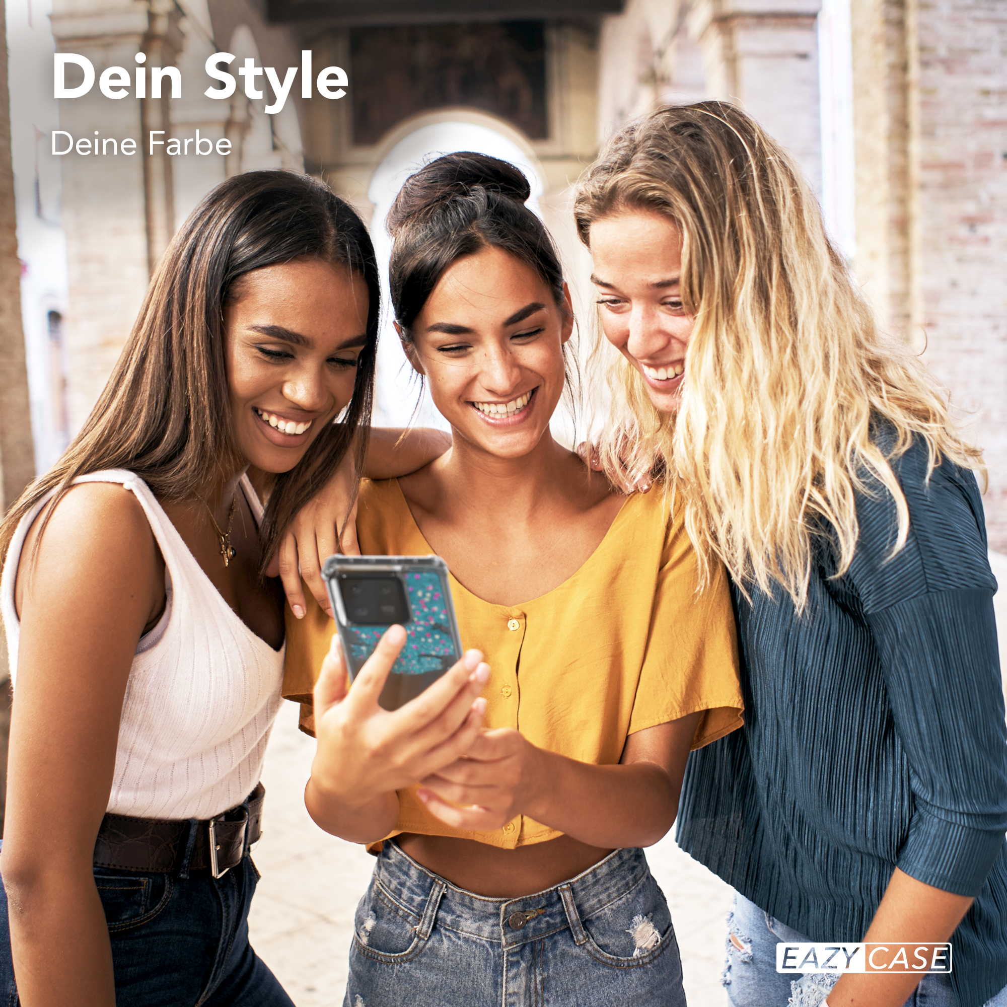 Drei junge Frauen lächeln, eine hält ein Telefon, mit Text 'Dein Style Deine Farbe'.