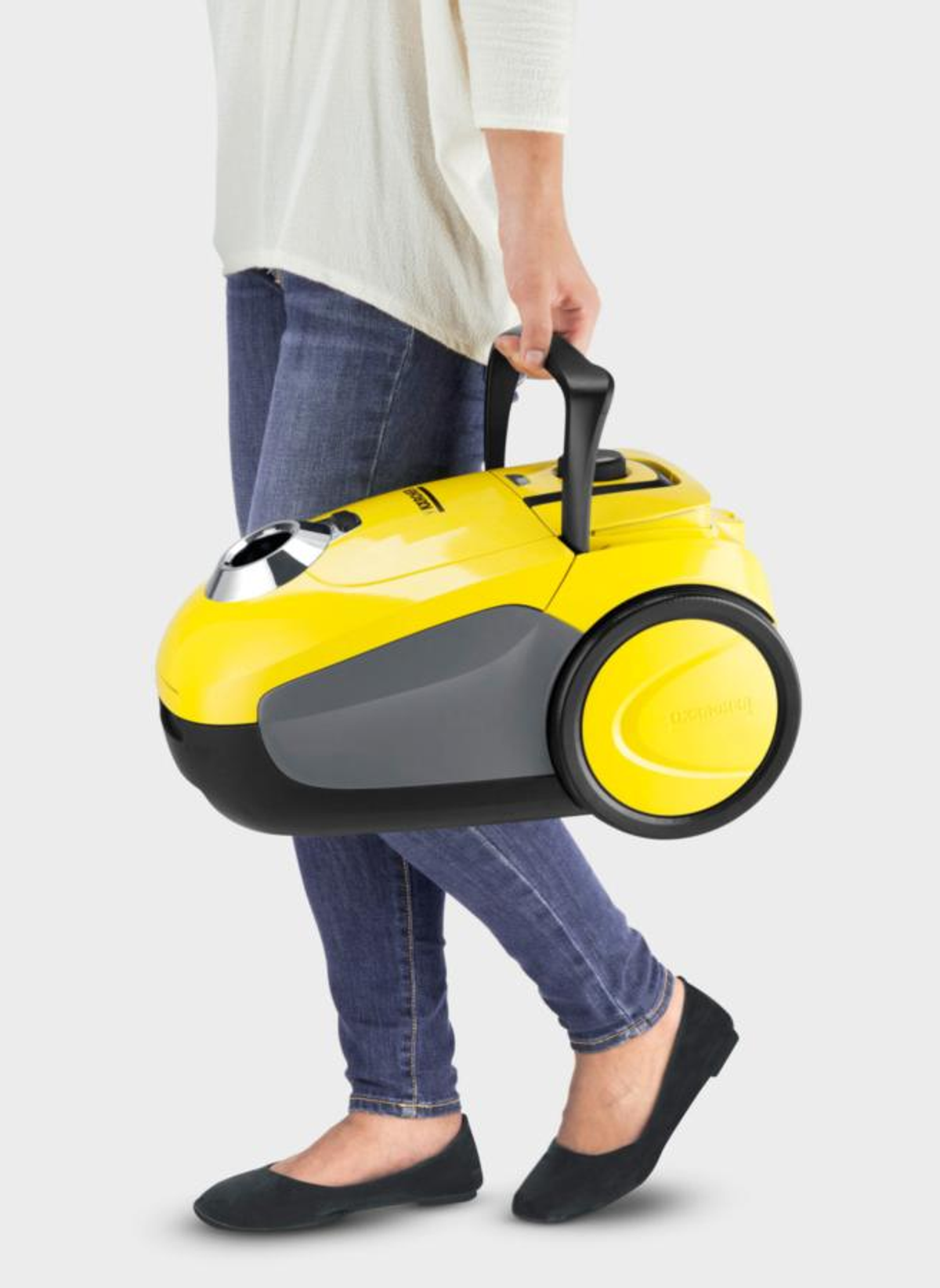 Una persona che trasporta un aspirapolvere giallo e grigio.