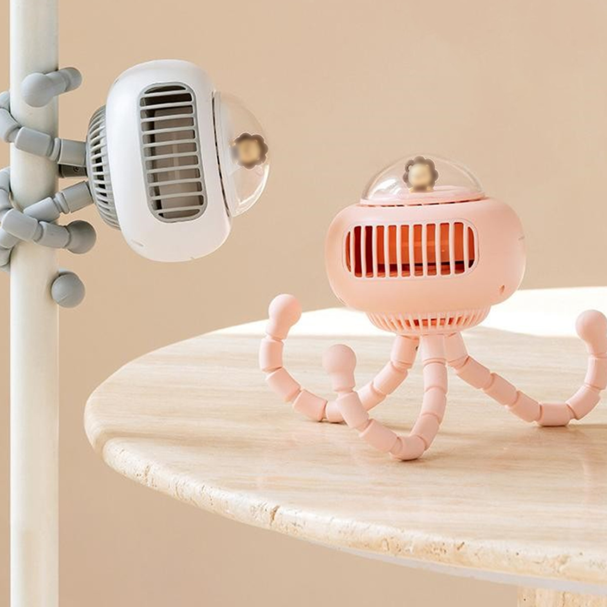 Zwei oktopusartige Ventilatoren, weiß und rosa, auf einem Tisch.