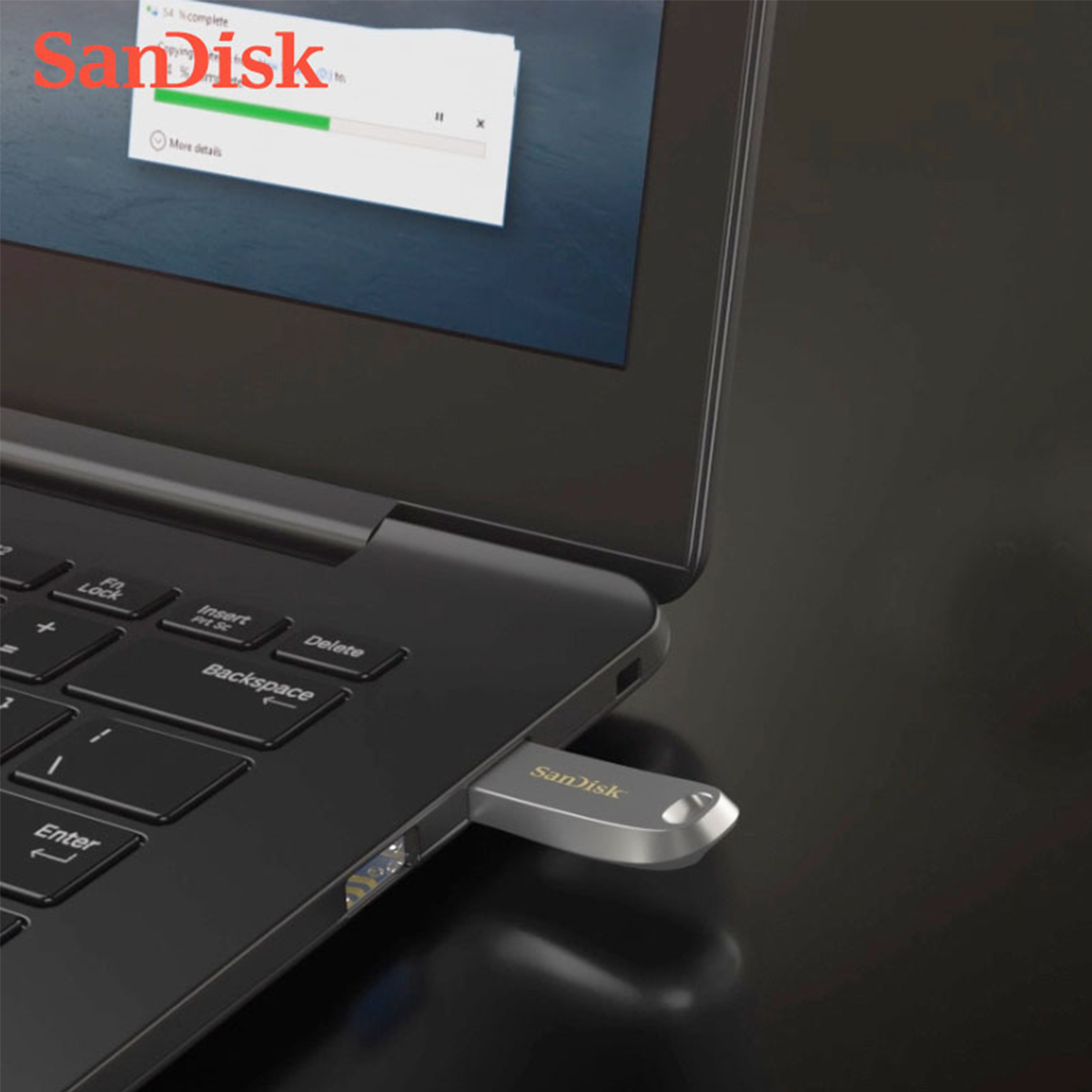 Laptop mit eingestecktem USB-Laufwerk. Das Laufwerk ist silberfarben, SanDisk Logo.