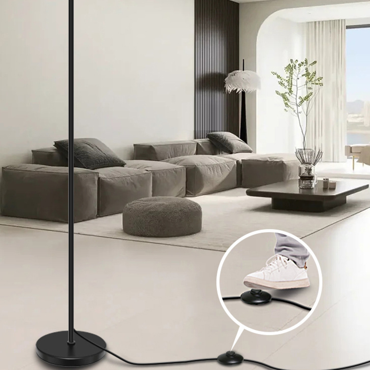 Schwarze Stehlampe mit Fußschalter im Nahaufnahme und hellem Innenraum im Hintergrund.