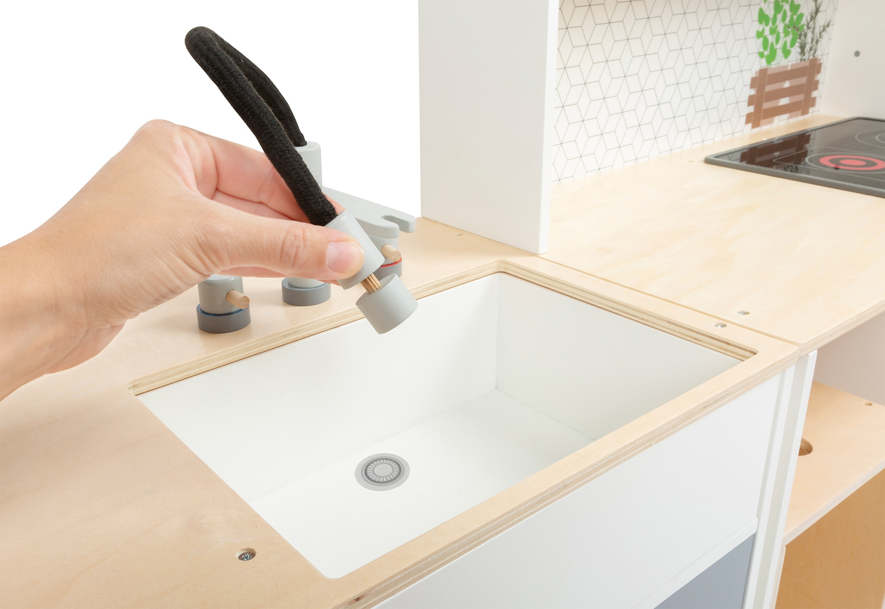 Holzspielküche mit einer Hand, die den Wasserhahn, das Waschbecken und die Arbeitsplatte hält.