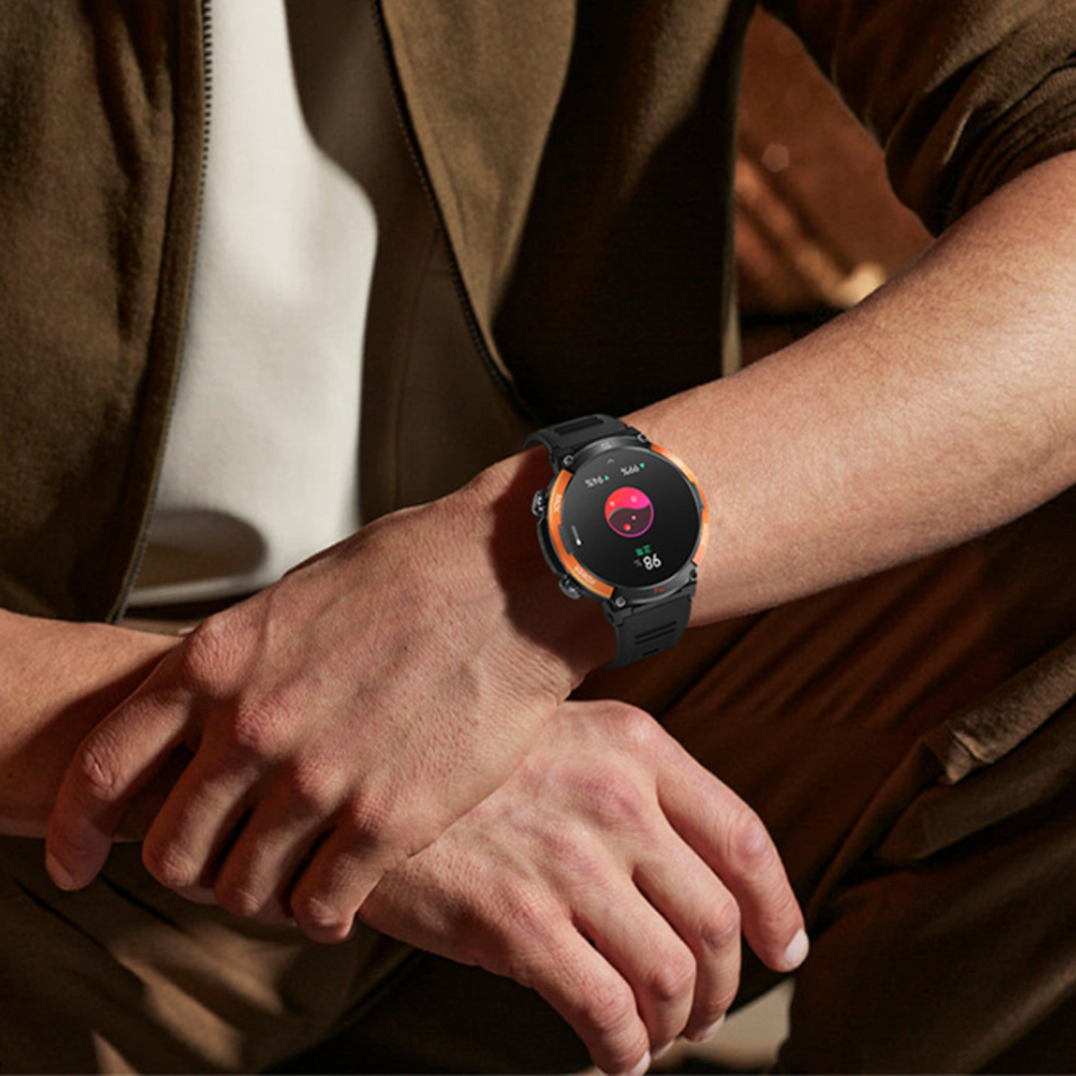 Eine Person trägt eine schwarz-orangefarbene Smartwatch. Die Uhr zeigt die Herzfrequenz auf dem Bildschirm.