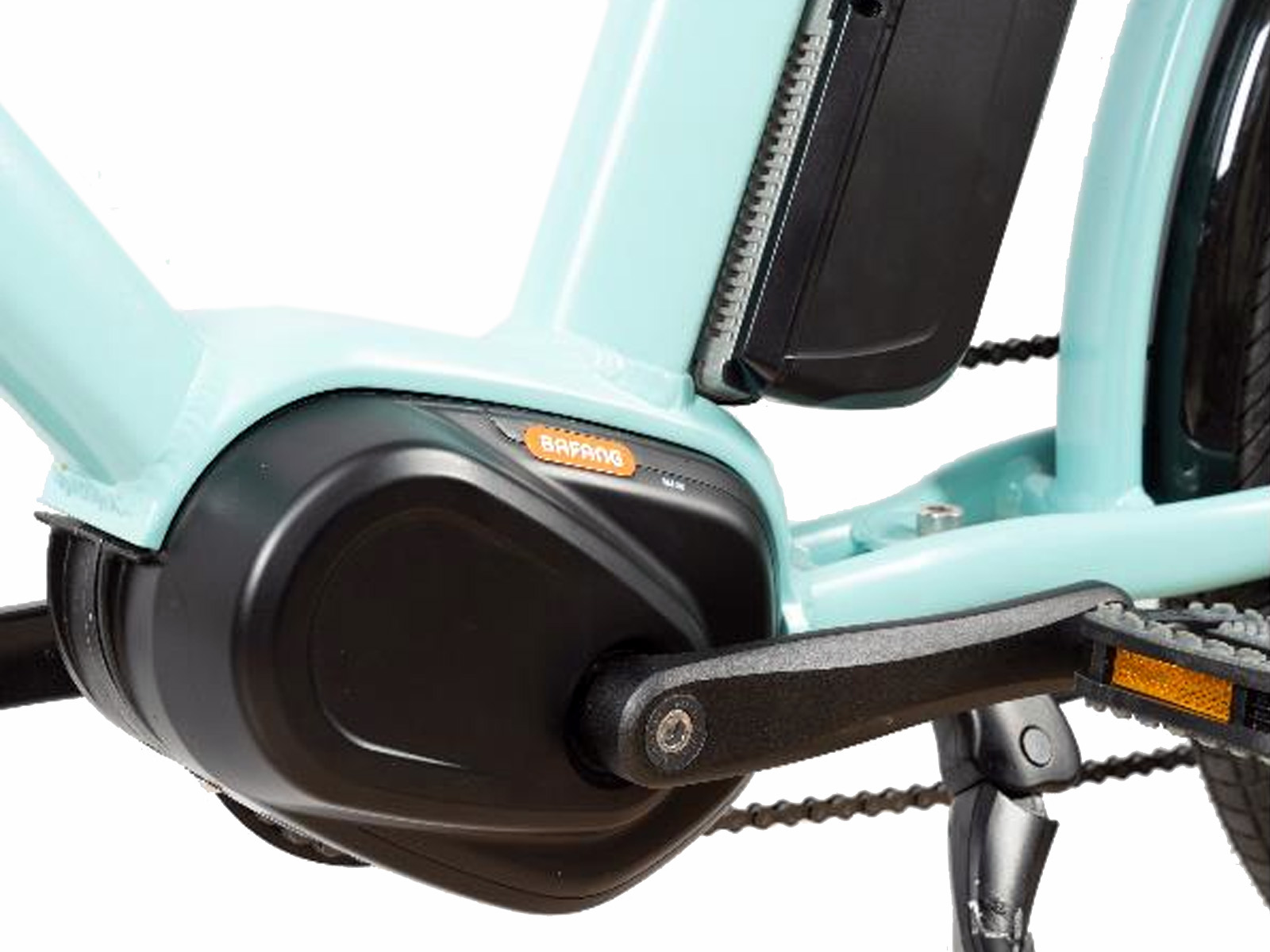 Primer plano de un motor de bicicleta eléctrica y un pedal en un marco turquesa. El motor es negro con un logotipo naranja.
