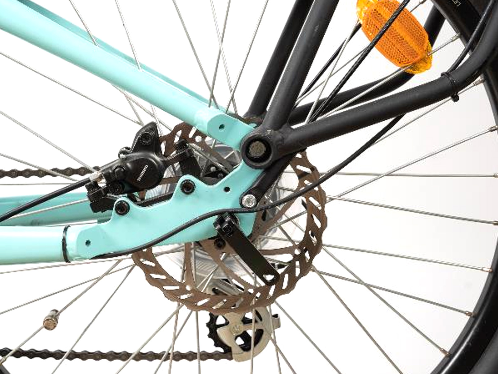 Primer plano de una rueda de bicicleta, freno de disco visible. El cuadro es azul claro y negro.