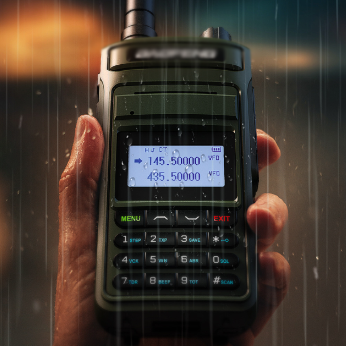 Ein grünes Baofeng Walkie-Talkie in einer Hand, mit Regentropfen, auf verschwommenem Hintergrund.