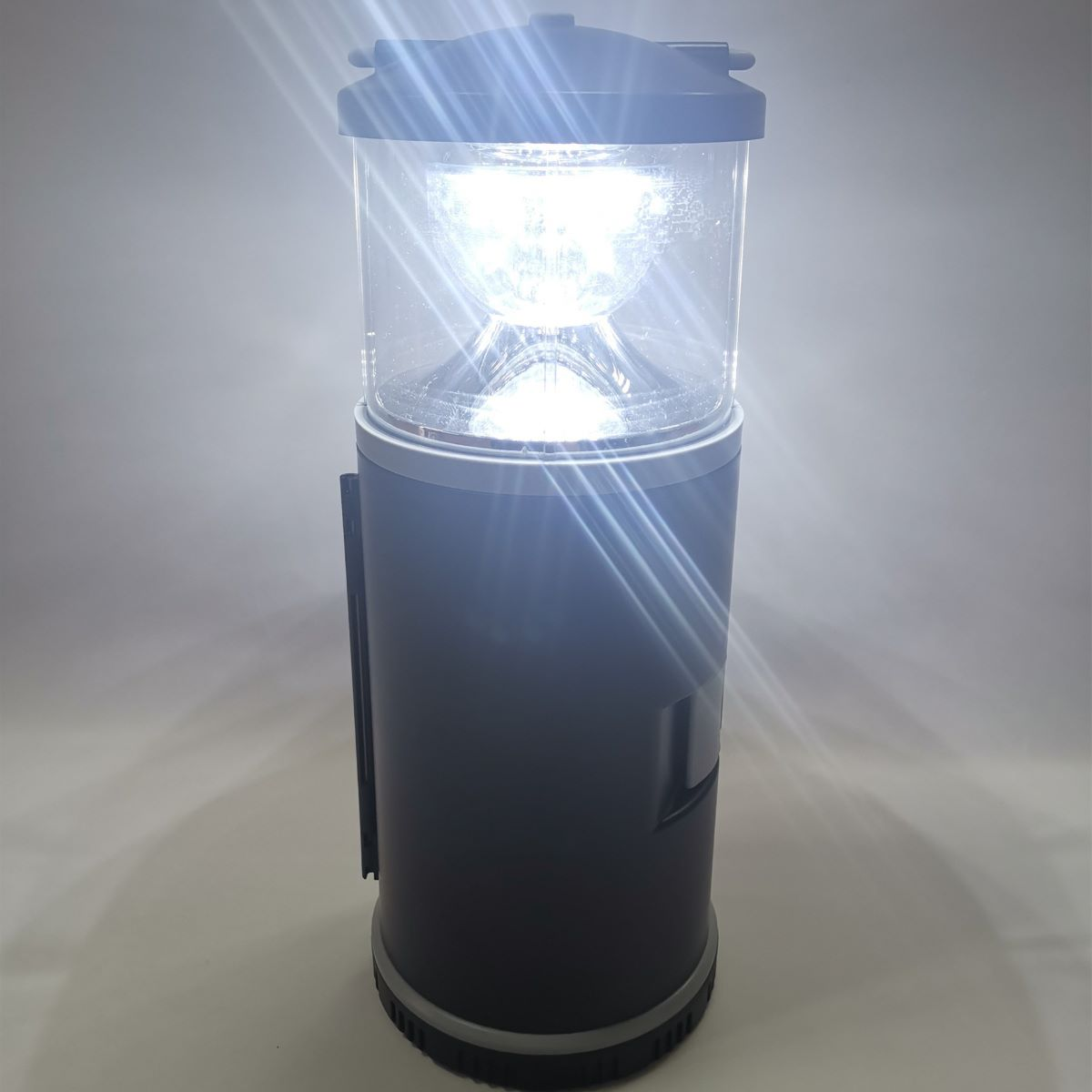 Eine schwarze und transparente Laterne mit hellem Licht ist beleuchtet. Sie steht auf weißem Hintergrund.