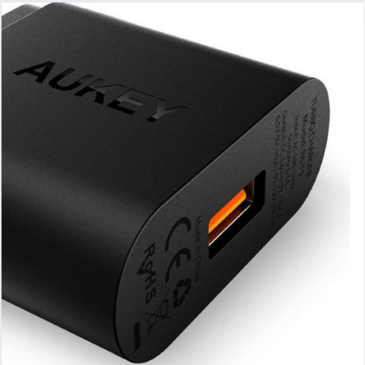 Ein schwarzes AUKEY-Wandladegerät mit einem orangefarbenen Ladeanschluss.