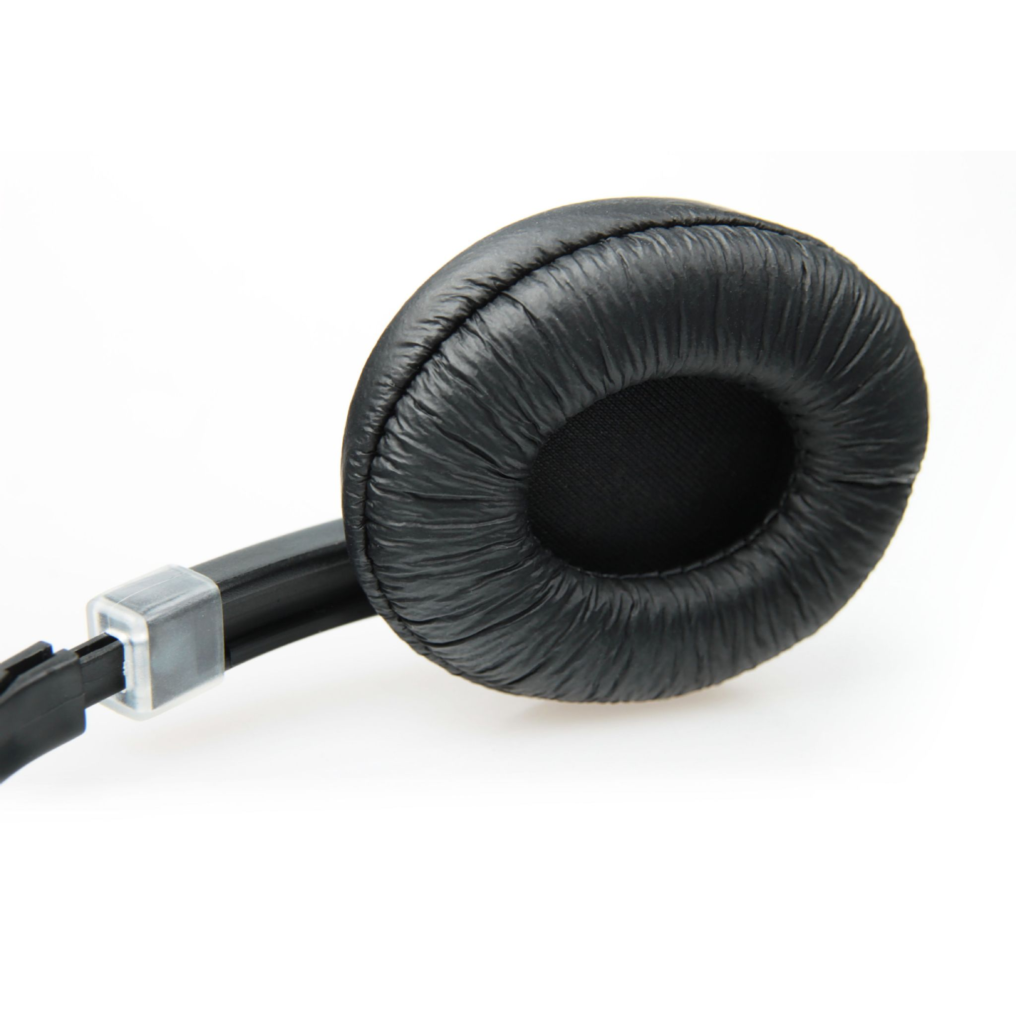 Czarna poduszka na słuchawki. Zbliżenie na białej powierzchni. Widoczna faktura podobna do skóry.