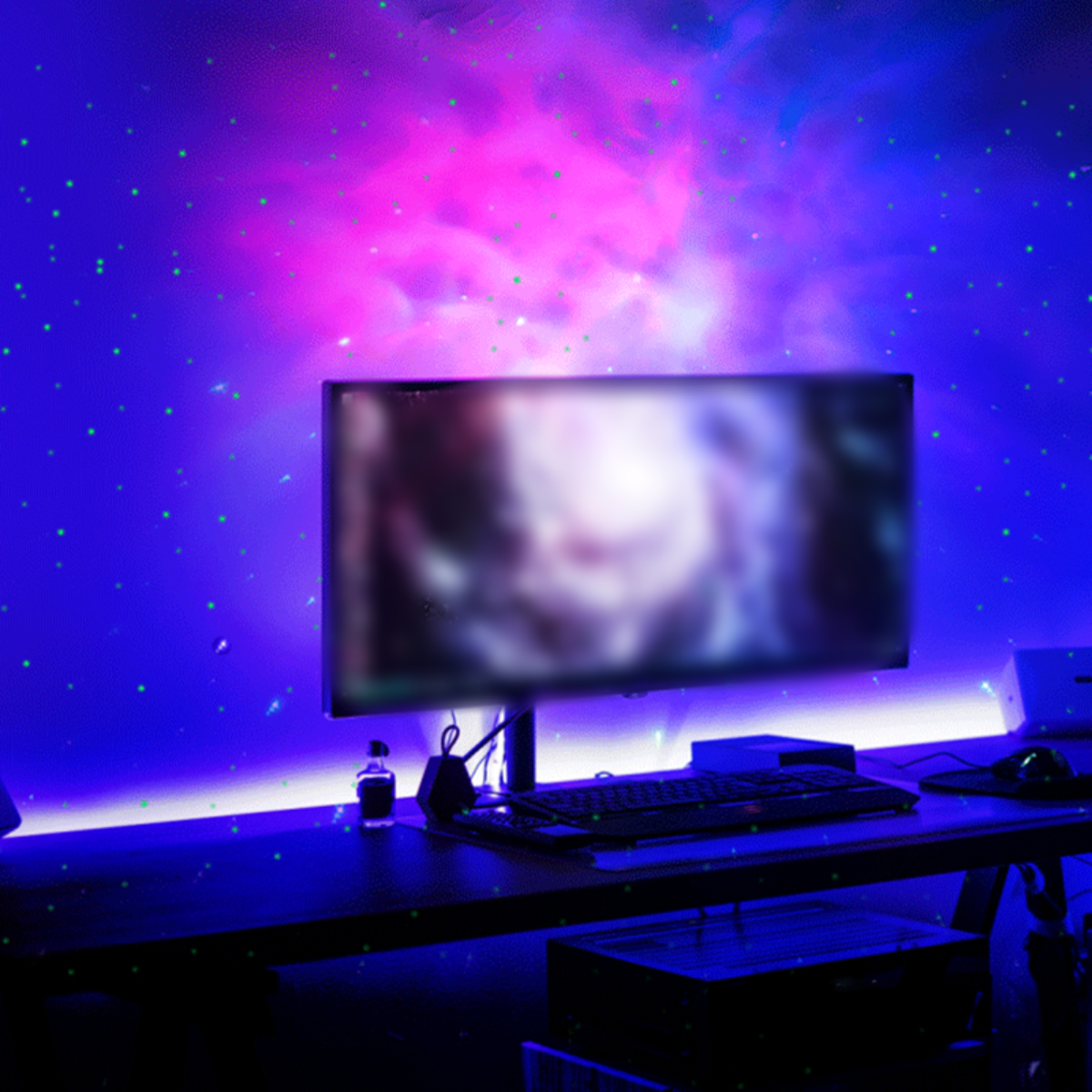 Ein Schreibtisch mit Monitor und Tastatur, beleuchtet durch eine rosa und blaue Lichtprojektion.