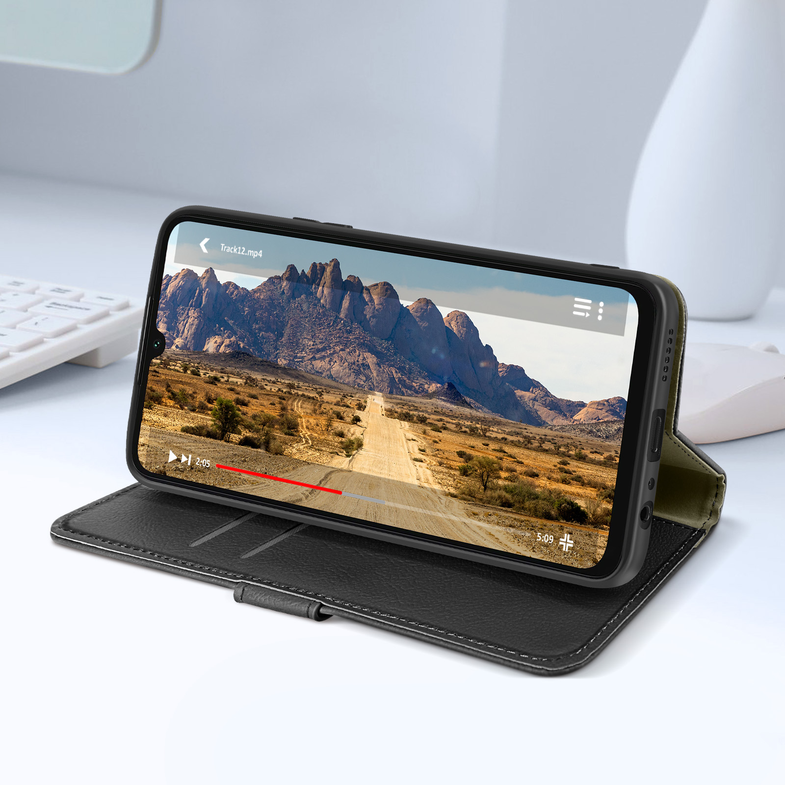 Uno smartphone in una custodia mostra un video di un paesaggio. Il telefono è su un supporto.