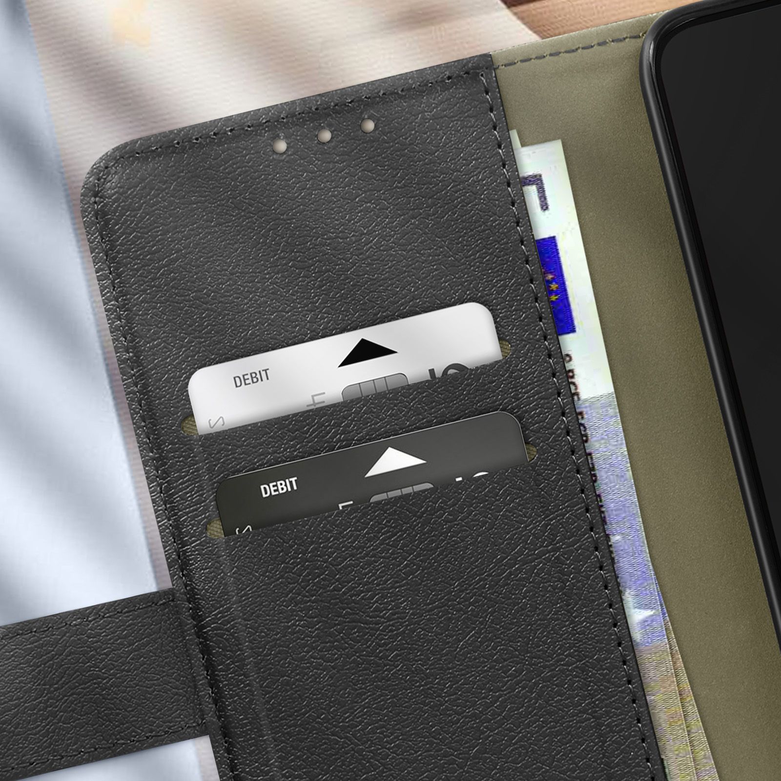 Una custodia per telefono nera con slot per carte, che contiene carte di debito e una banconota europea.