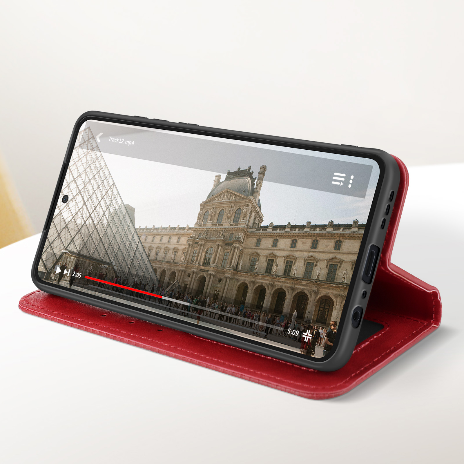 Telefono in custodia rossa, mostra video di un edificio, con controlli video sullo schermo.