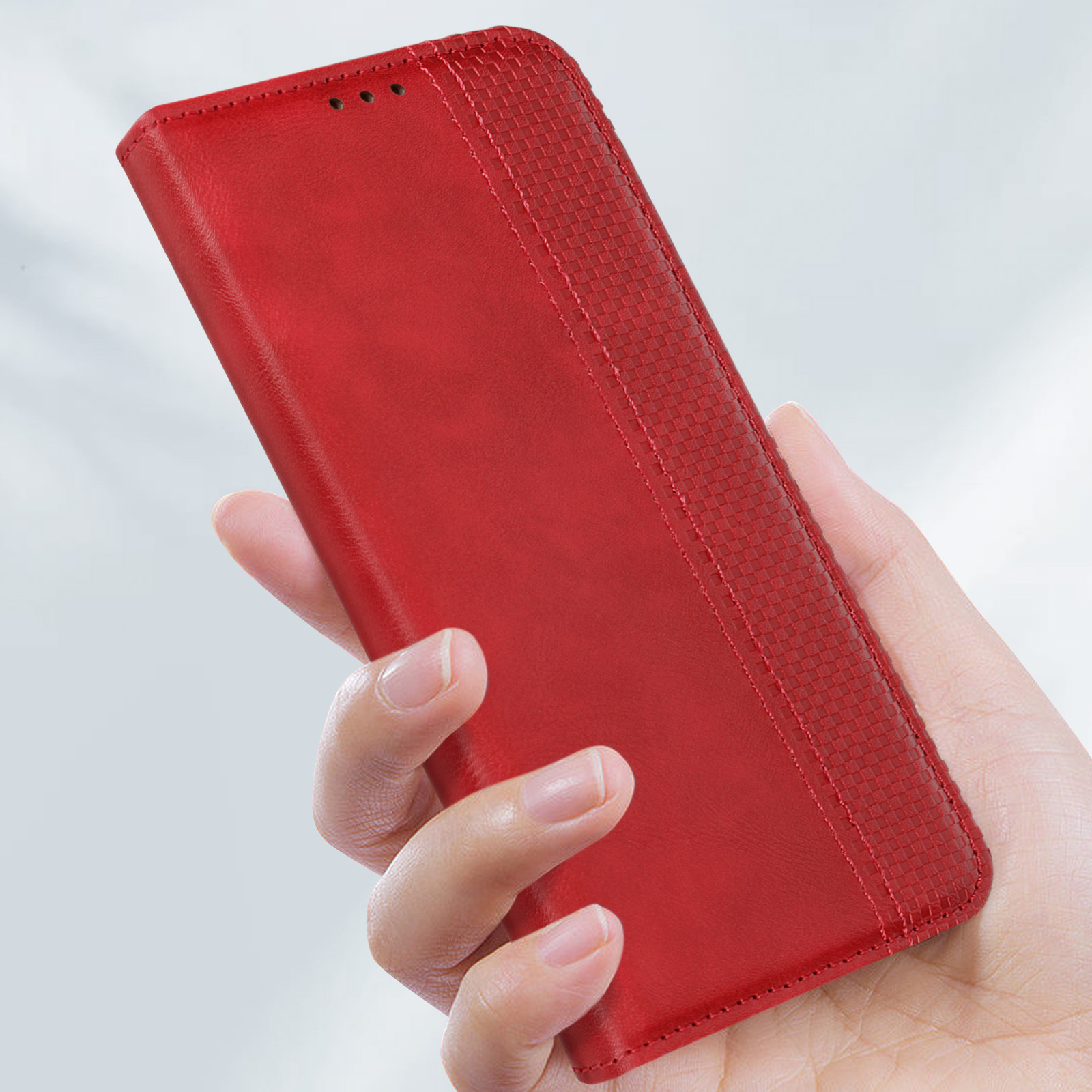 Custodia rossa per telefono in mano. La custodia è chiusa e ha un design strutturato.
