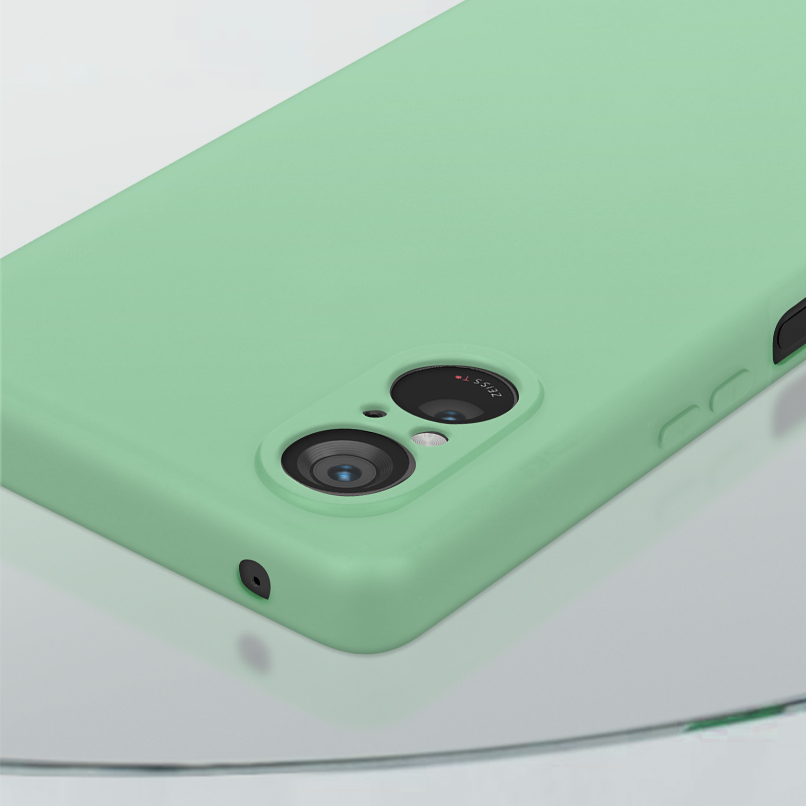 Primo piano di un telefono verde menta con lenti della fotocamera.