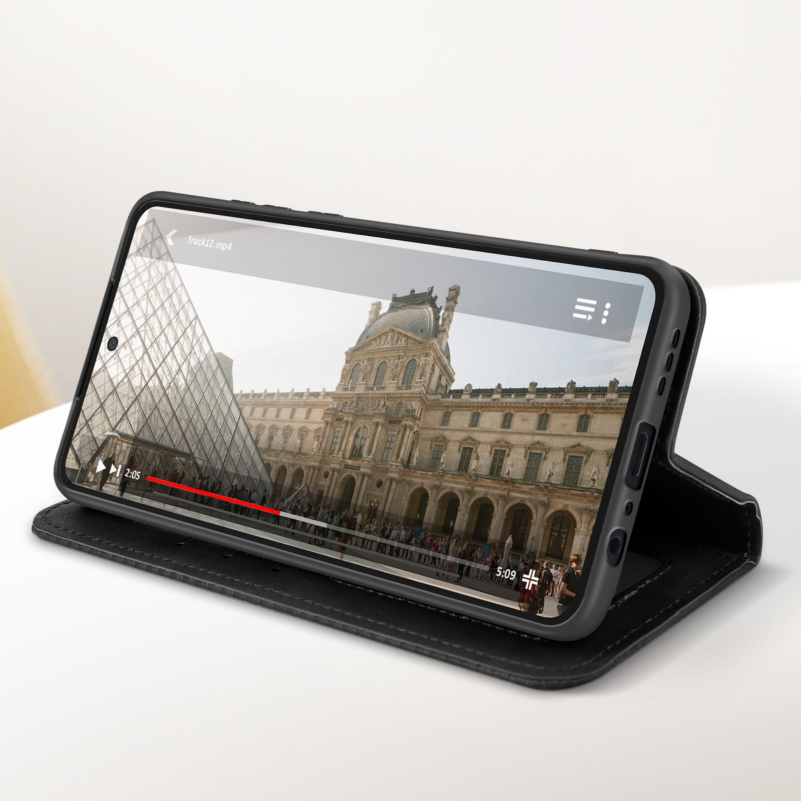 Uno smartphone in una custodia nera, che mostra un video su uno schermo, con la custodia aperta.