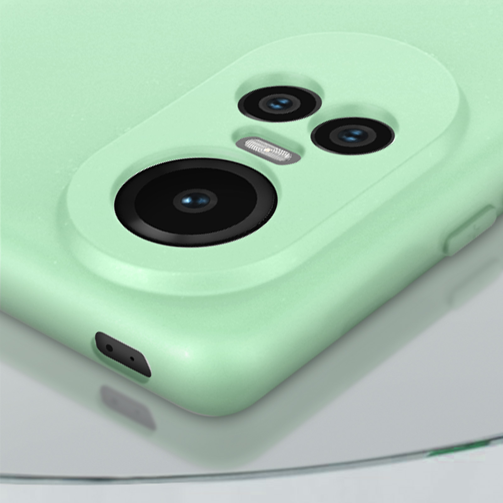 Dettaglio fotocamera telefono verde. Tre lenti visibili.