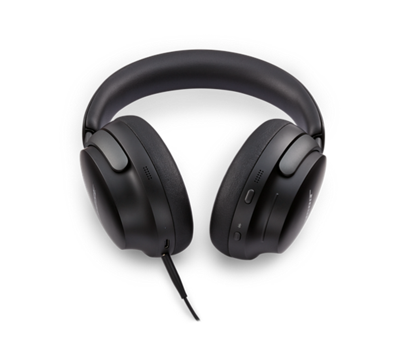 Czarne słuchawki na czarnym tle. Słuchawki mają kabel i elementy sterujące z boku.