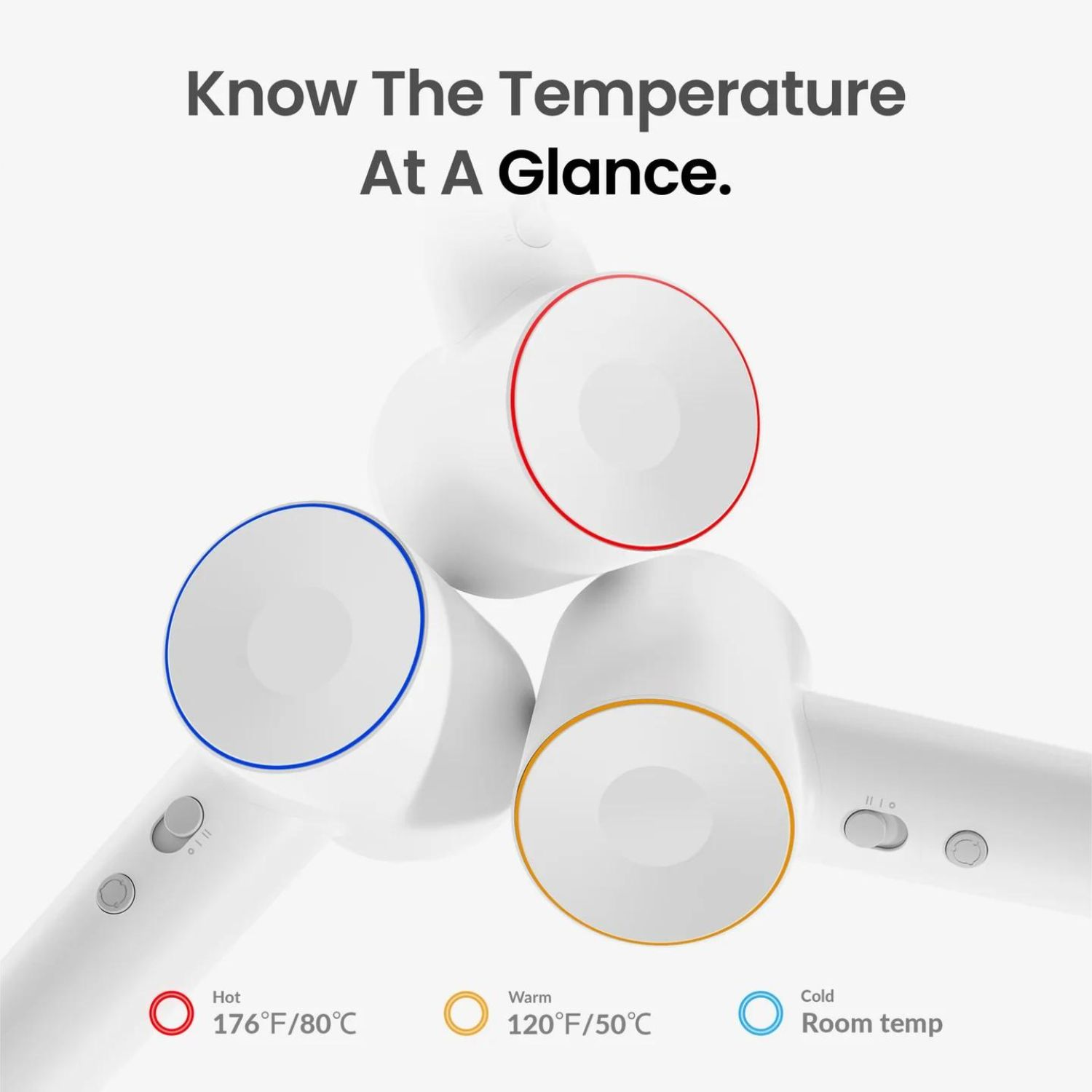 Tres secadores de pelo blancos con anillos codificados por colores que indican la temperatura. Se ven anillos rojos, amarillos y azules.