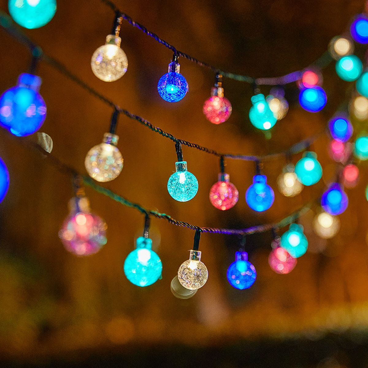 Lichterkette mit vielen bunten Glühbirnen. Der Hintergrund ist verschwommen.