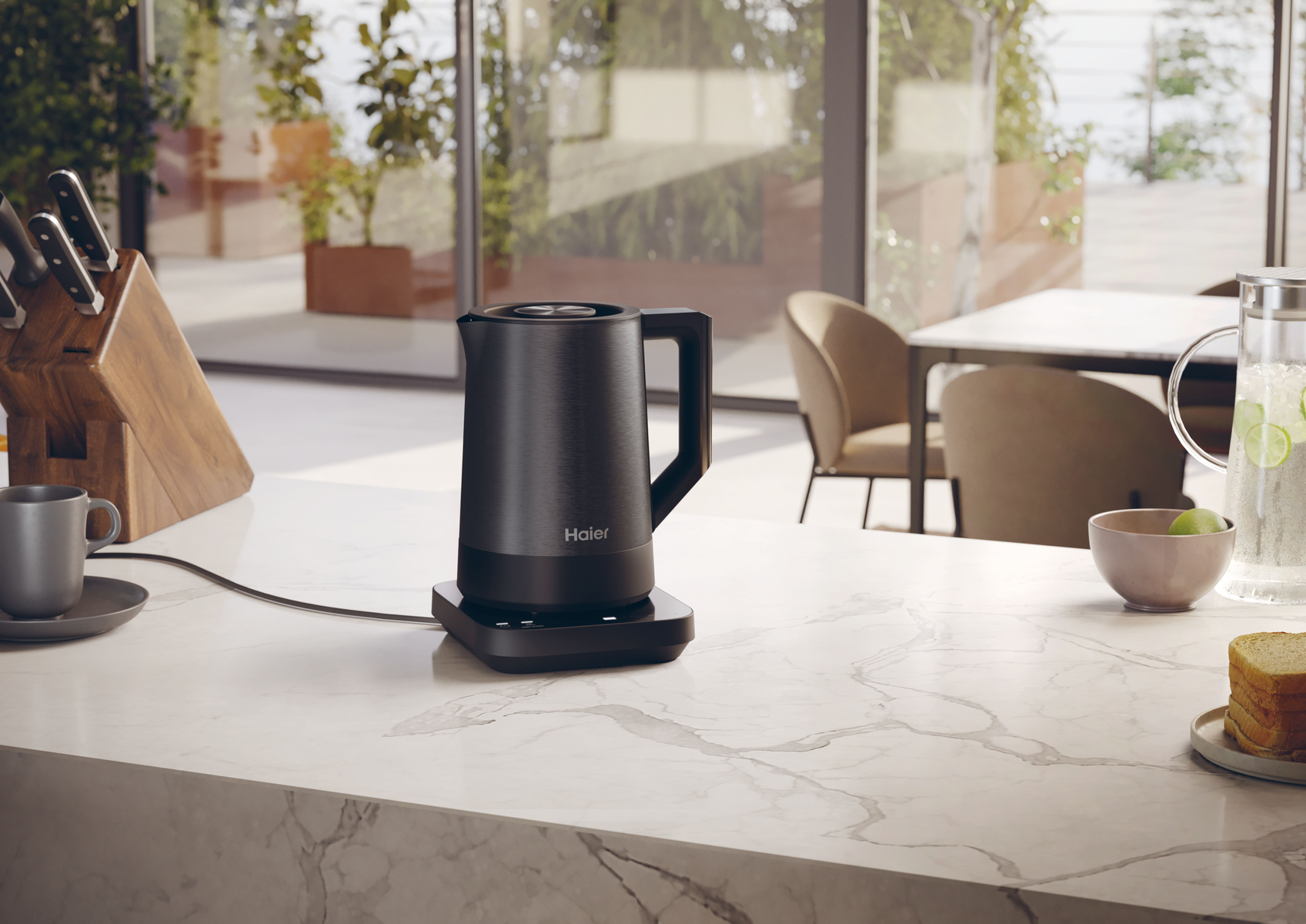 Czarny czajnik elektryczny na czarnym stojaku na marmurowym blacie.