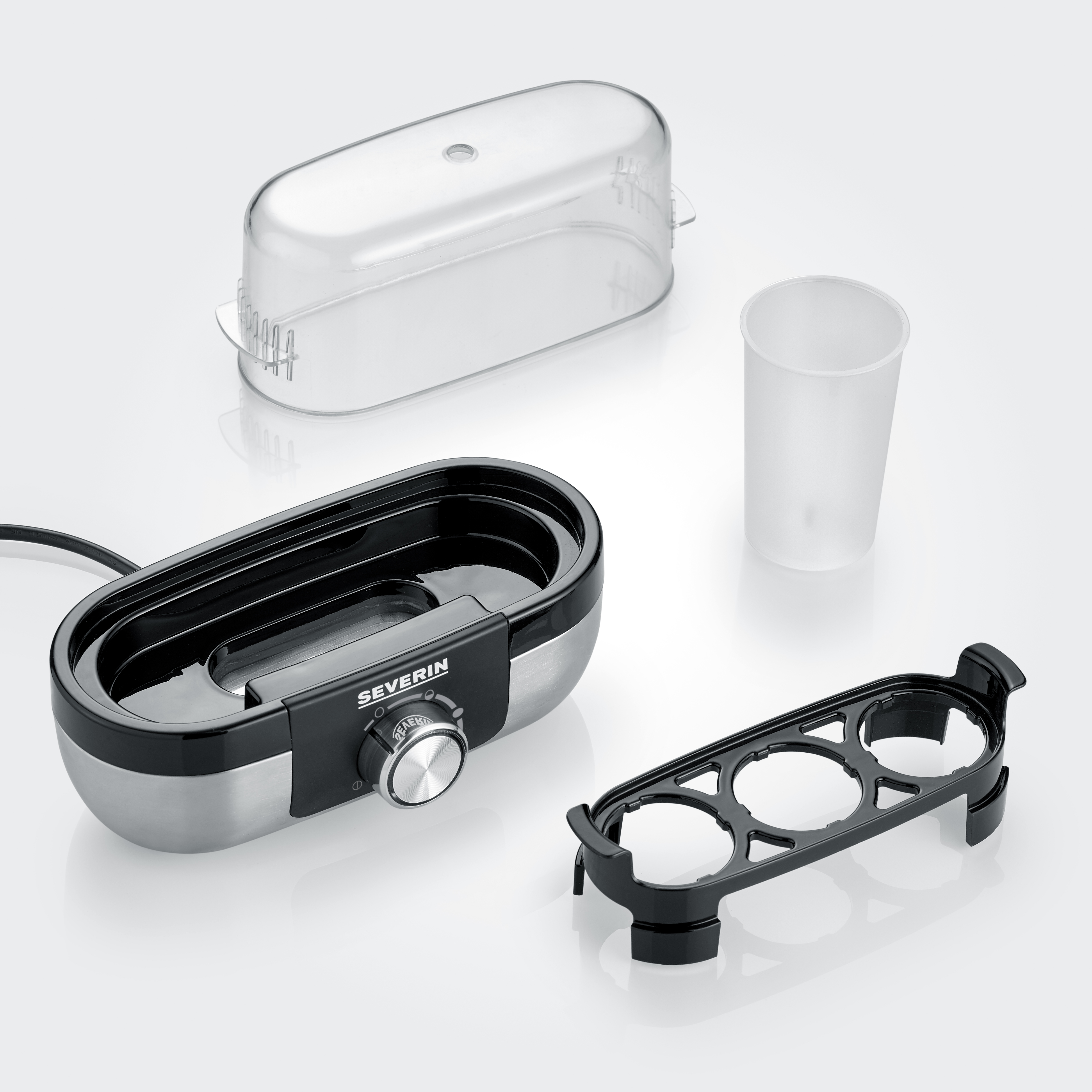 Gotowacz do jajek z częściami. Czarny i stal nierdzewna. Przezroczysta pokrywa i miarka. Części na białej powierzchni.