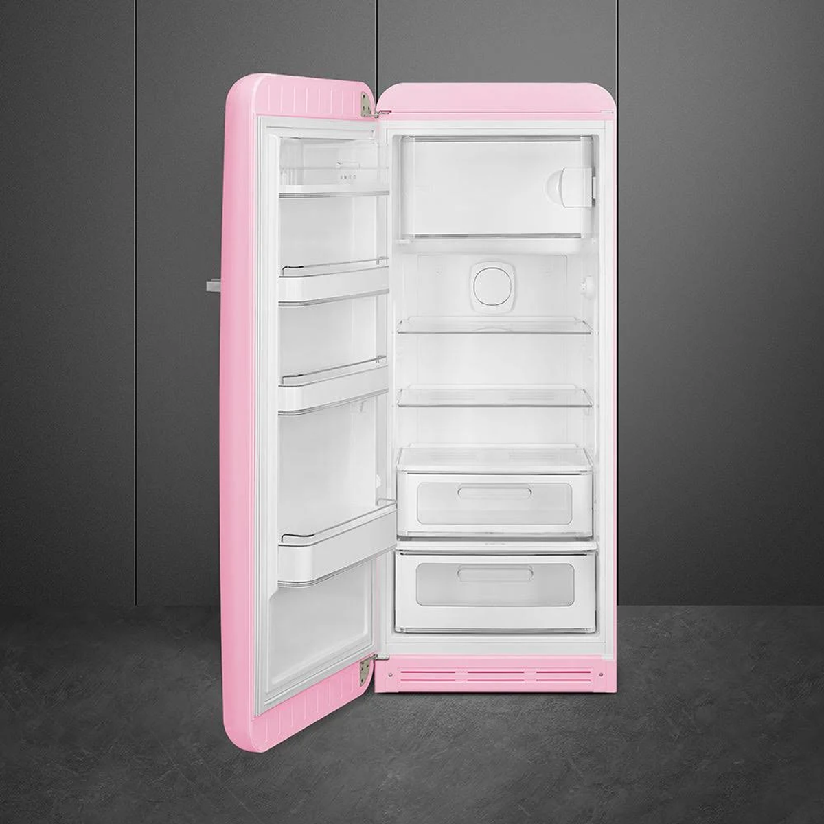 Frigorifero retrò rosa con la porta aperta, che rivela ripiani e cassetti.