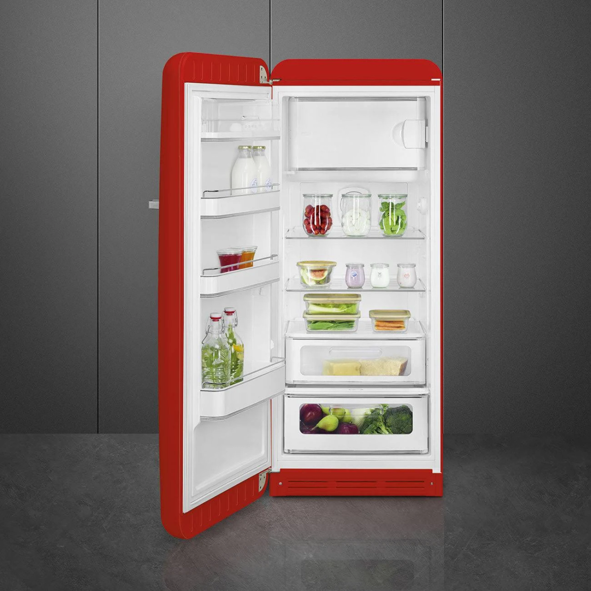 Frigorifero rosso con la porta aperta, pieno di generi alimentari.