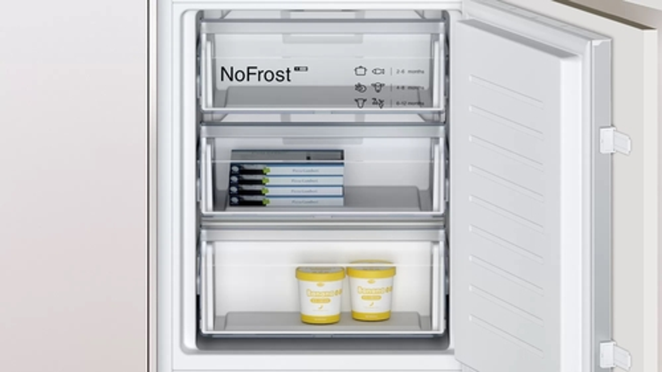 Refrigerador blanco con puerta abierta. Estantes y cajones visibles. El interior es blanco.