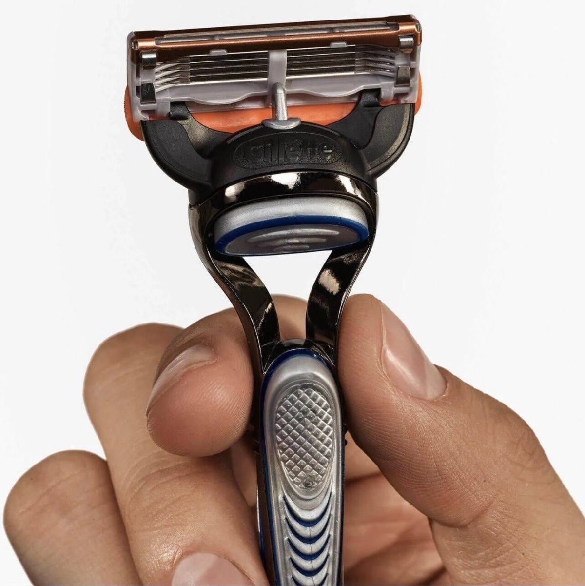 Primo piano di un rasoio Gillette tenuto in mano. È di colore argento e blu.