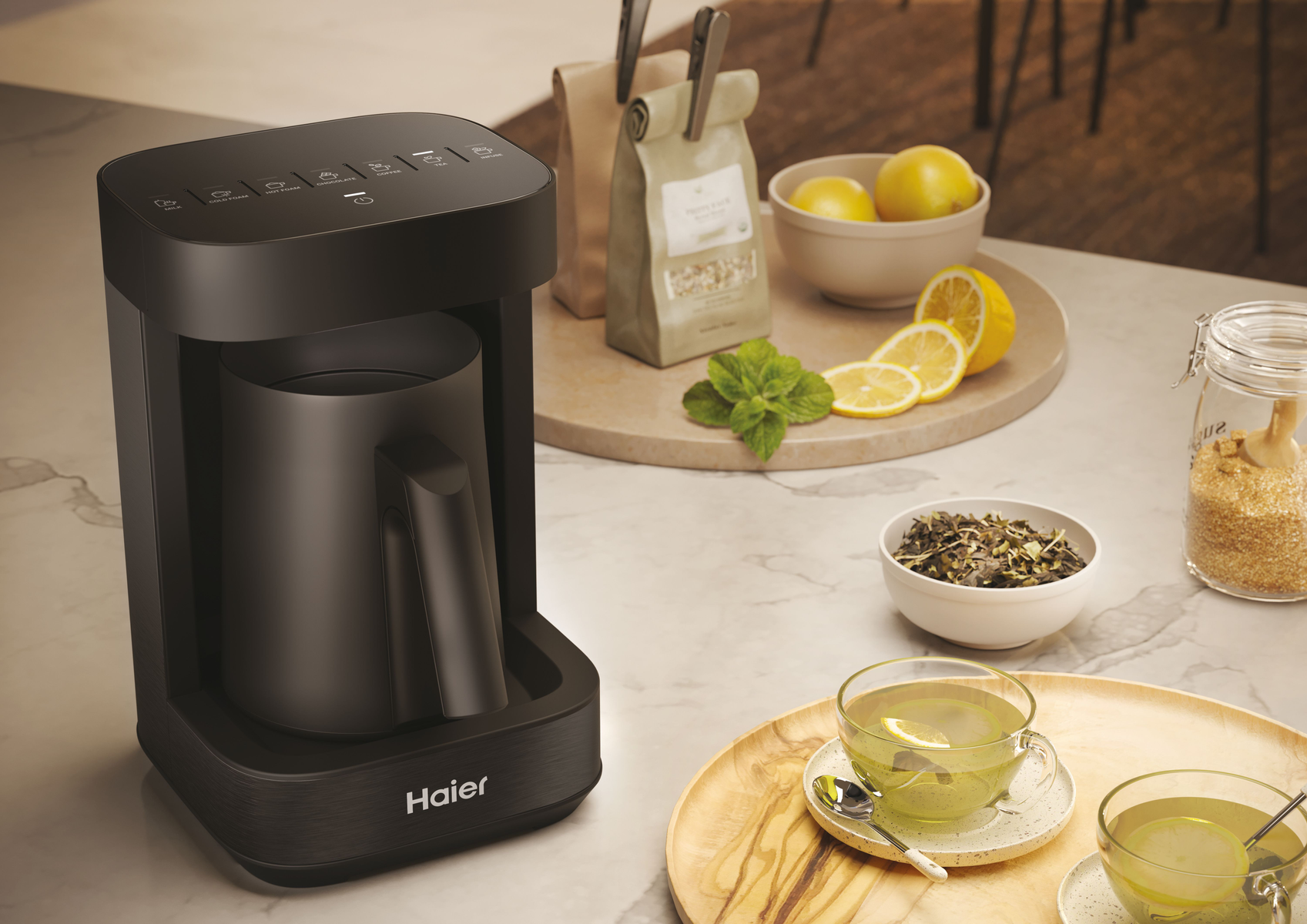 Macchina da caffè nera su un tavolo, limoni, tè e accessori.