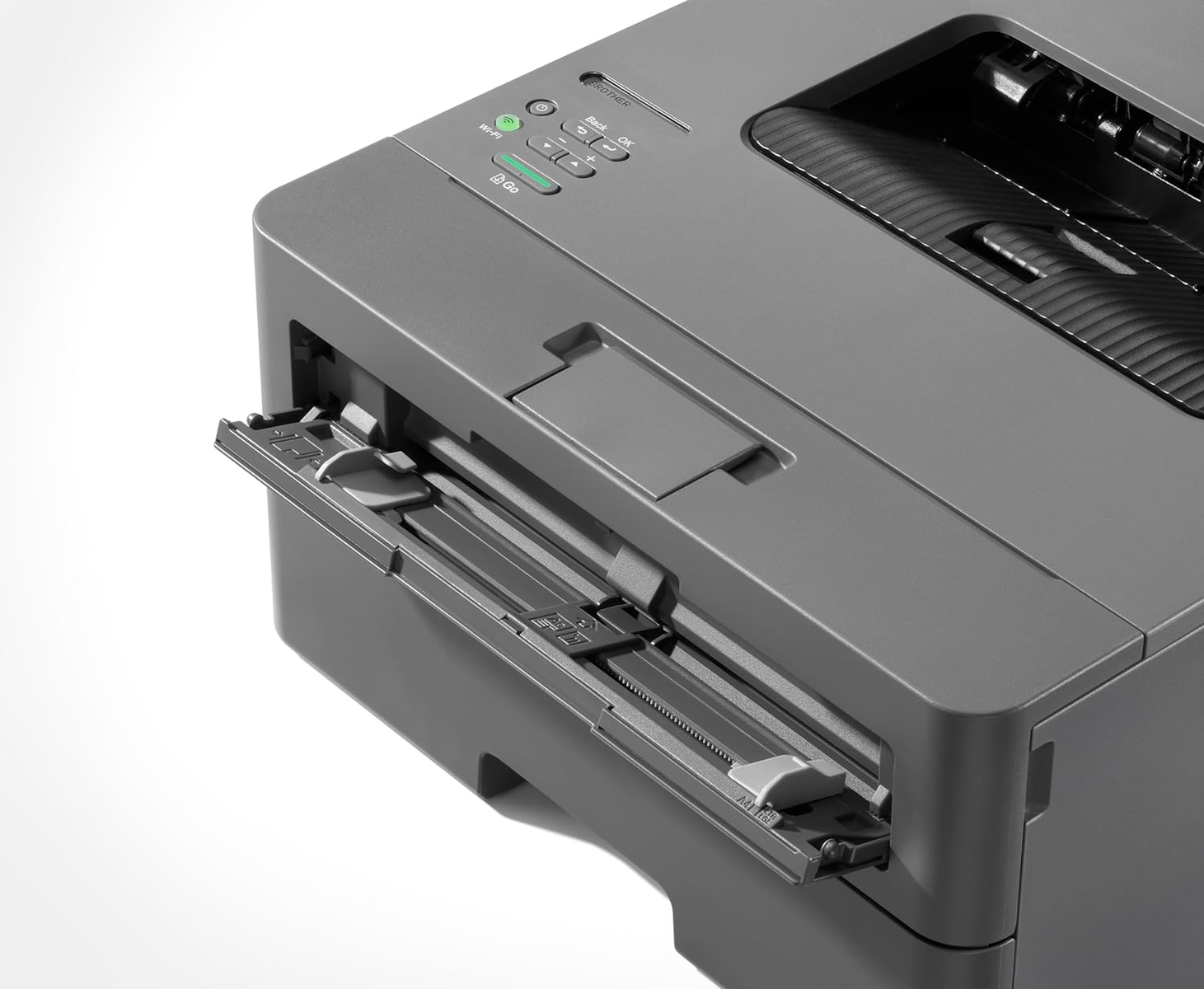 Szara drukarka Brother z wysuniętą tacą na papier, na białej powierzchni, widok z boku.