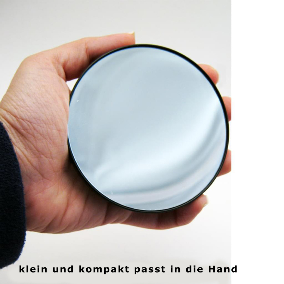 Hand, die einen runden Spiegel hält. Der Spiegel reflektiert eine helle, weiße Umgebung.