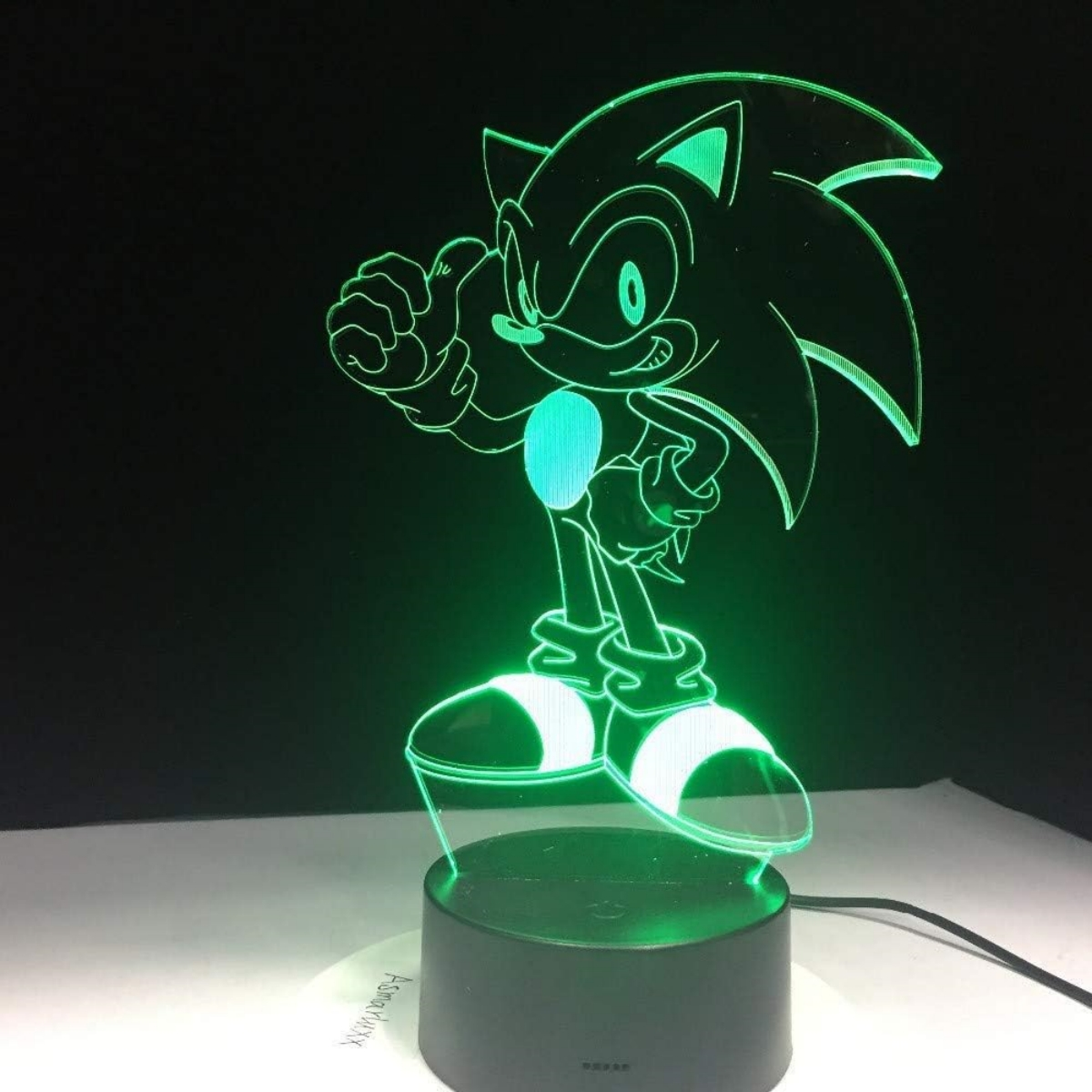 Sonic the Hedgehog Figur in Grün beleuchtet. Steht auf schwarzem Sockel vor dunklem Hintergrund.
