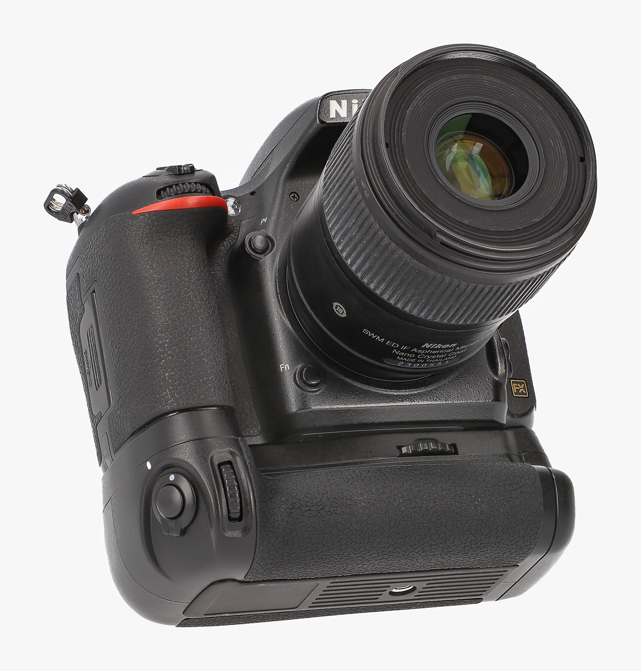 Schwarze Nikon-Kamera mit großem Objektiv, aus niedriger Perspektive vor weißem Hintergrund aufgenommen.