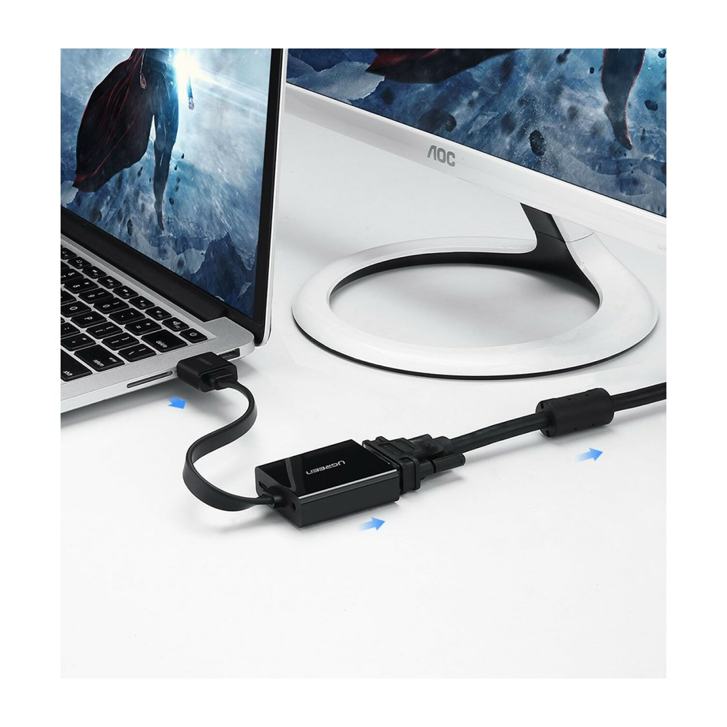 Laptop podłączony do monitora. Monitor jest biały. Pomiędzy nimi znajduje się czarny konektor.