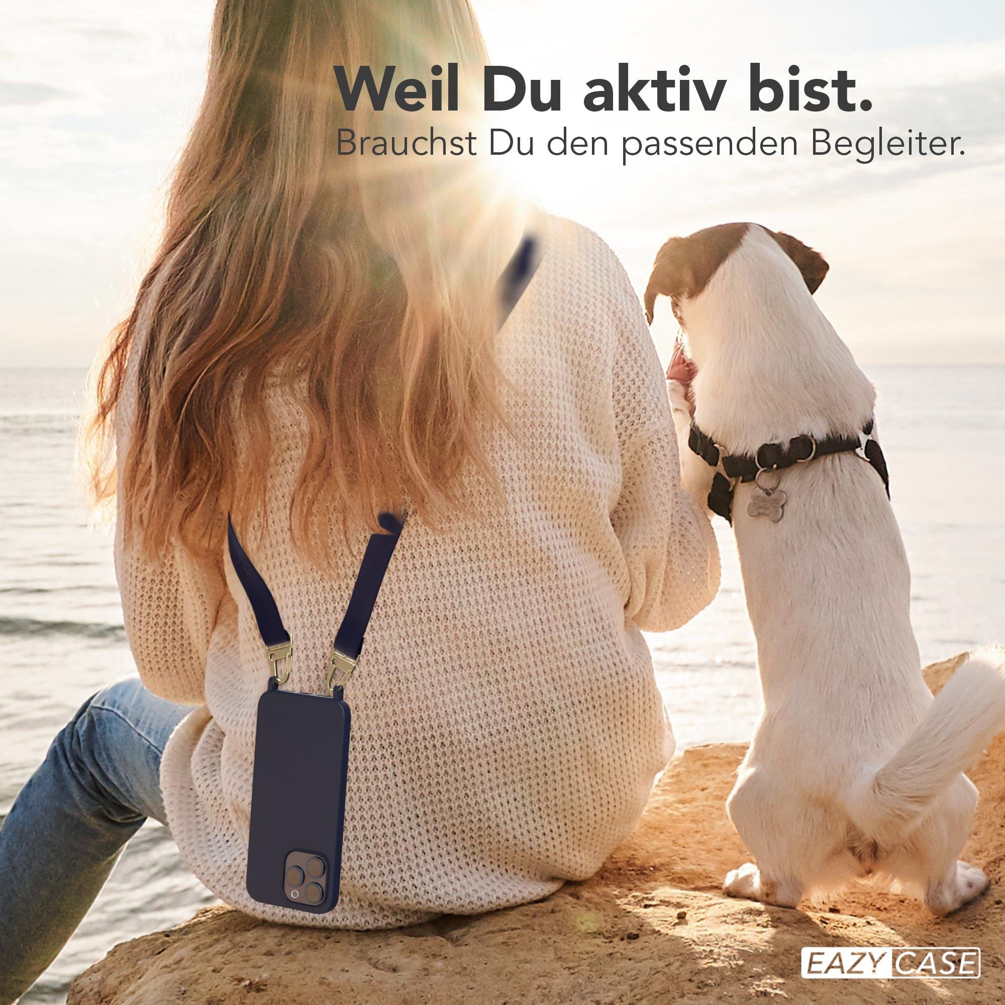 Frau mit Handy am Gurt und Hund. Sie sind am Strand. Das Telefon ist in einer Hülle.