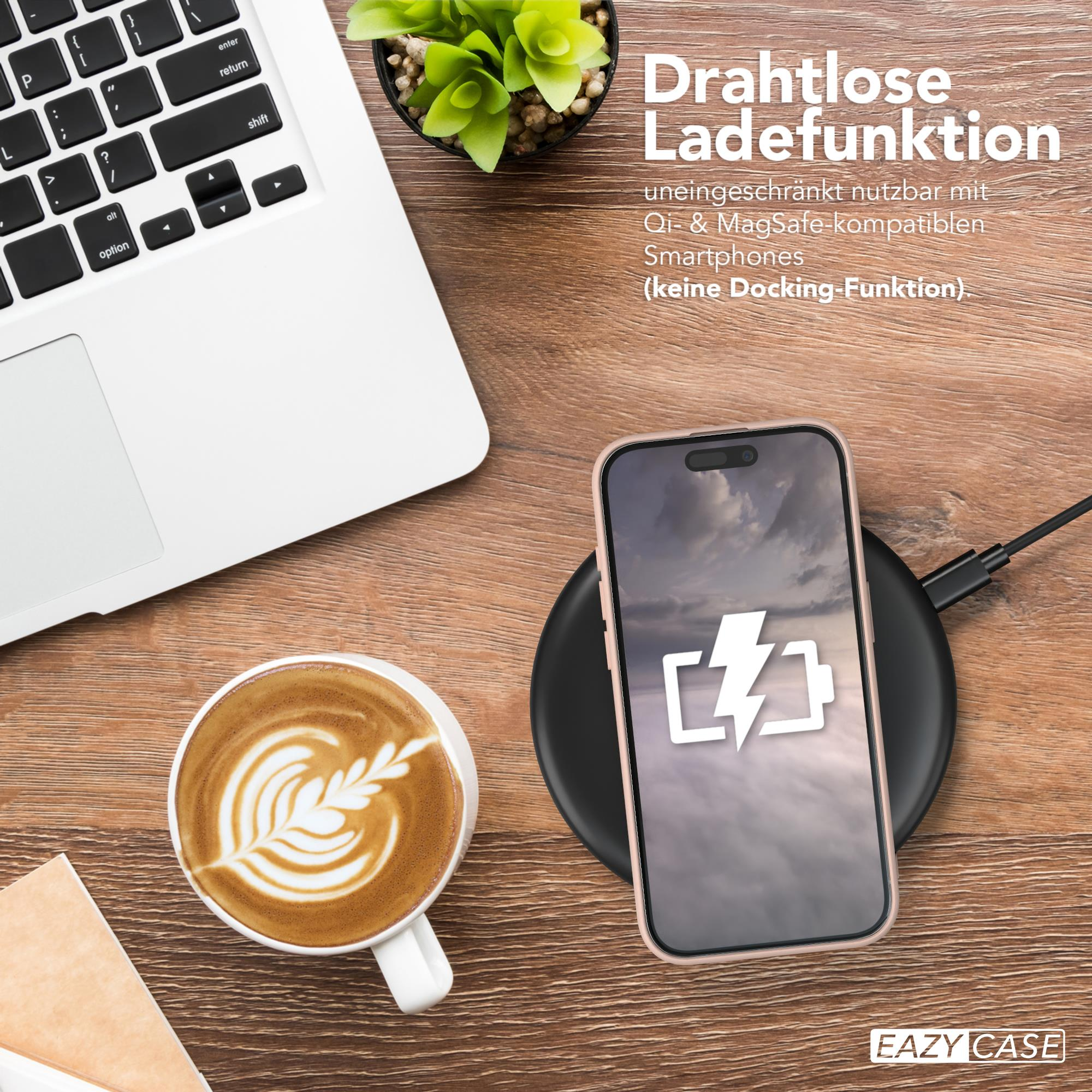 Laptop, Telefon auf kabellosem Ladegerät, Kaffeetasse und Pflanze auf einem Holztisch. Telefon zeigt Ladesymbol.