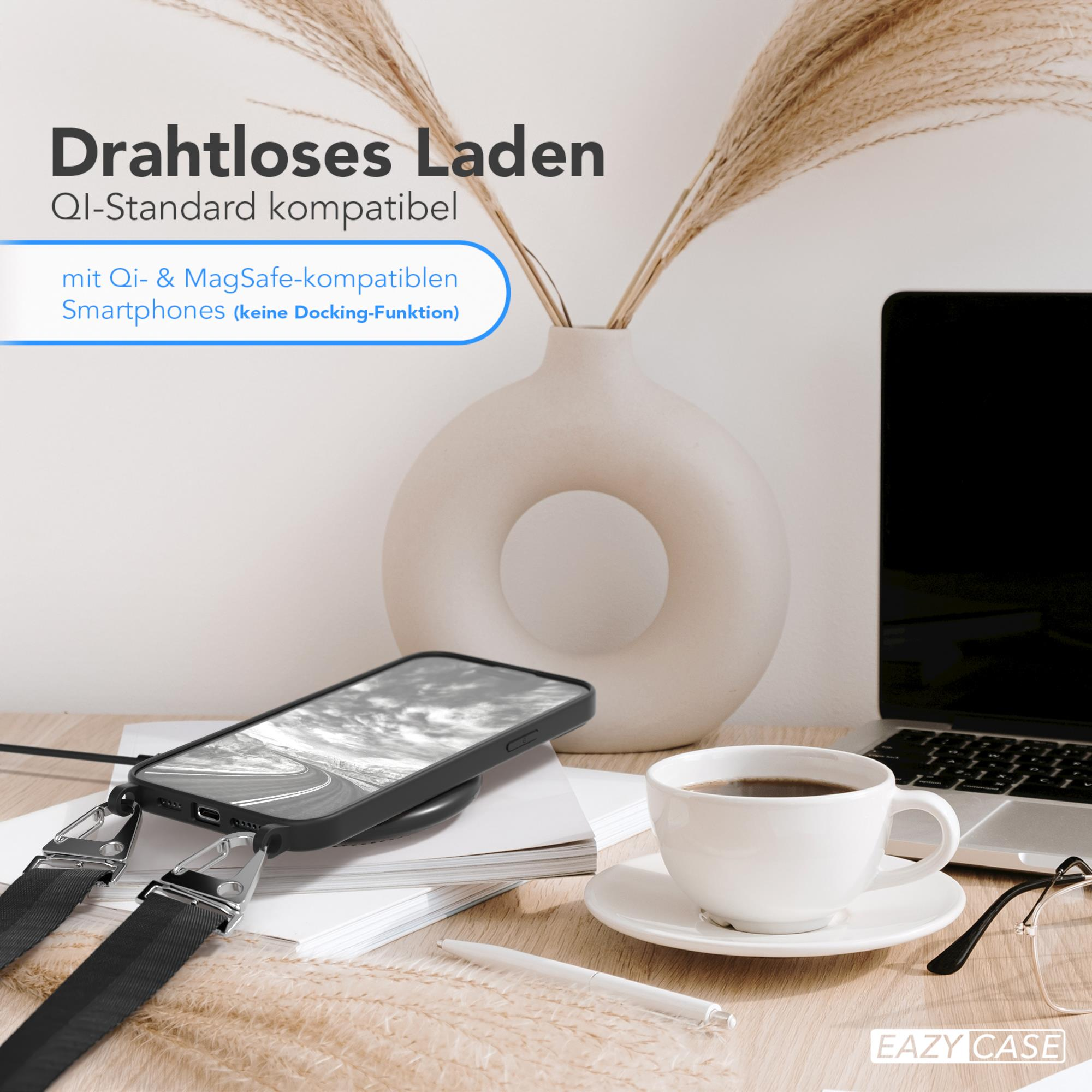 Schwarzes Telefon, das drahtlos auf einer weißen Oberfläche mit Kaffee und Stift geladen wird.