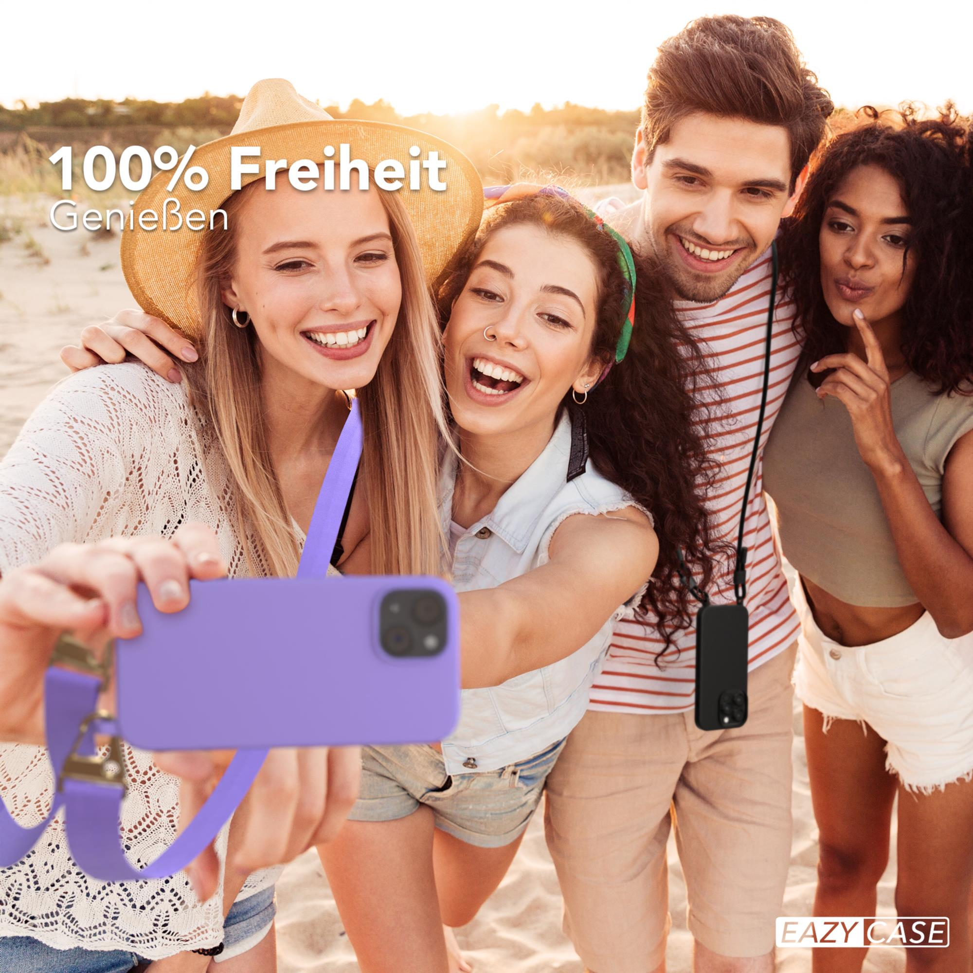 Vier Personen machen ein Selfie am Strand. Einer hält ein Telefon mit lila Hülle. Sonniger Hintergrund.