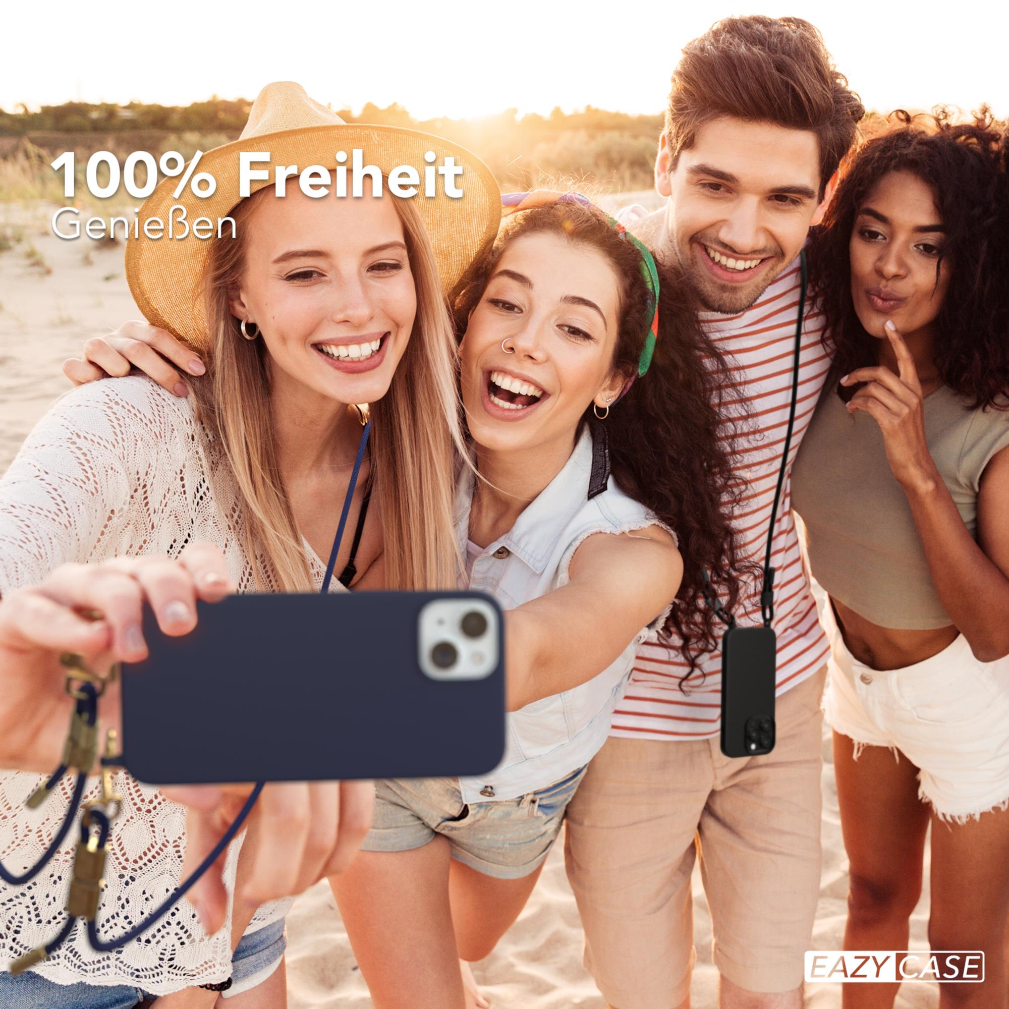Vier Leute lächeln und machen ein Selfie mit einem Handy am Strand.