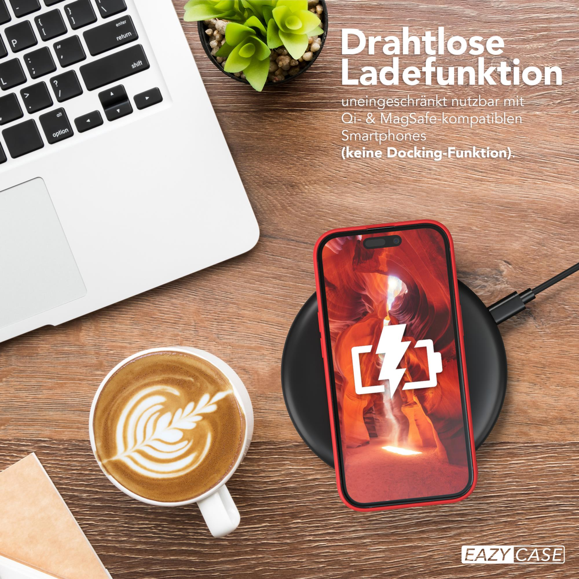 Ein rotes Telefon, das drahtlos auf einem schwarzen Pad neben einer Kaffeetasse und einem Laptop geladen wird.