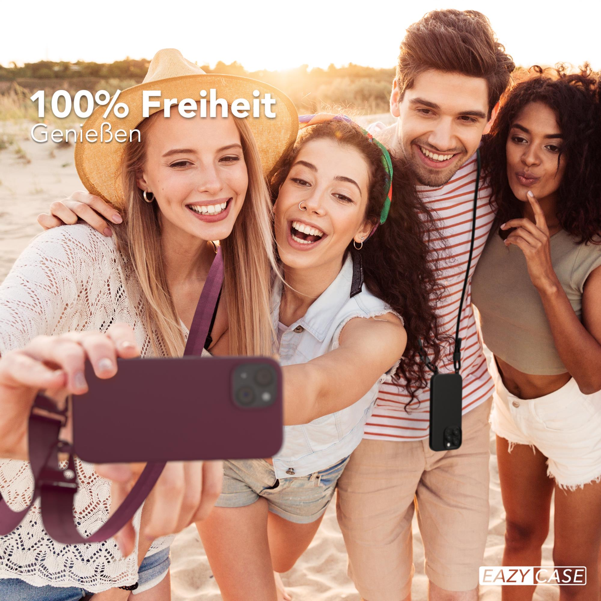 Vier Personen machen ein Selfie am Strand. Einer hält ein Telefon in roter Hülle.