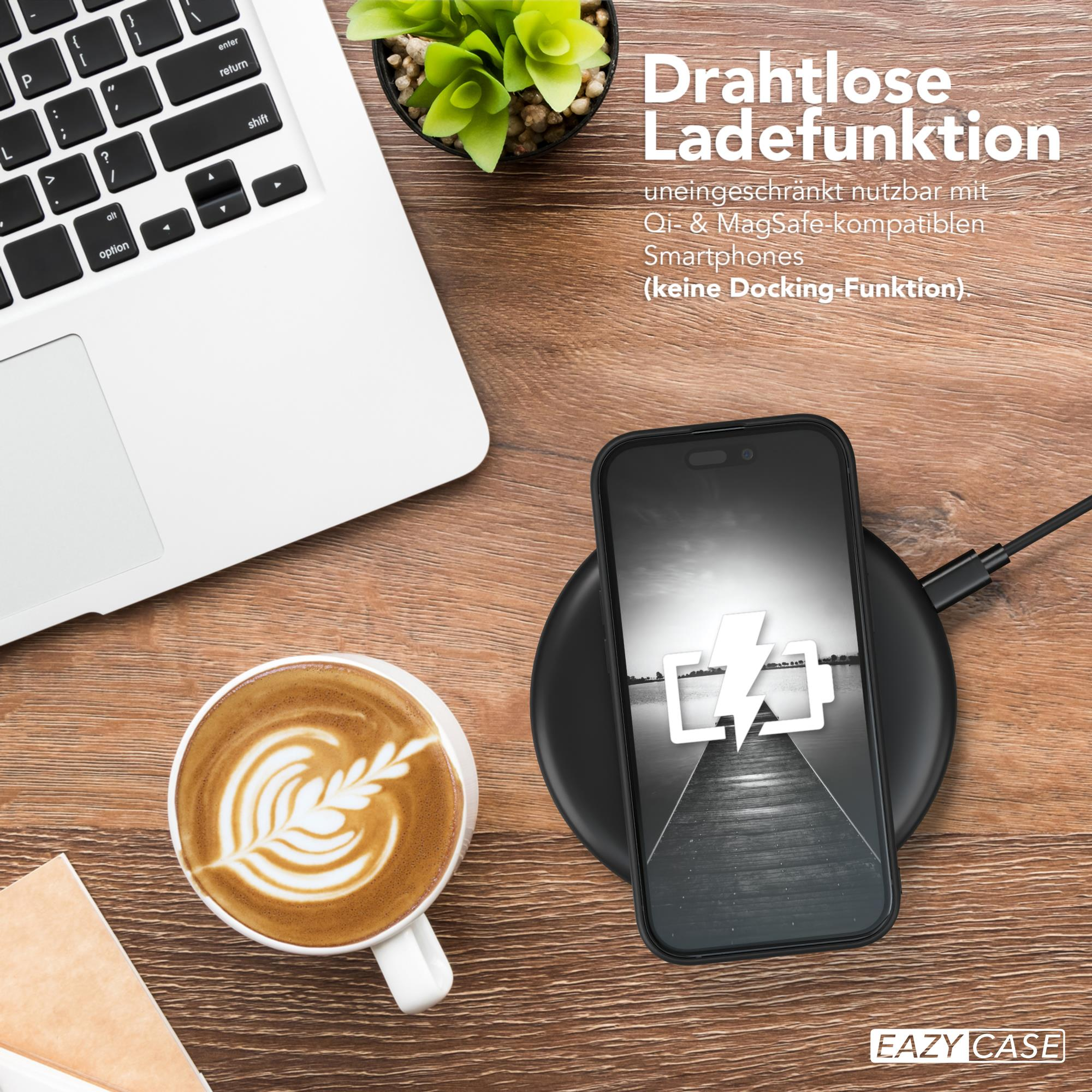 Ein schwarzes Telefon, das drahtlos auf einem Ladepad geladen wird. Eine Tasse Kaffee und ein Laptop stehen auf dem Tisch.